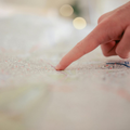 Finger tracing a colorful map on a table