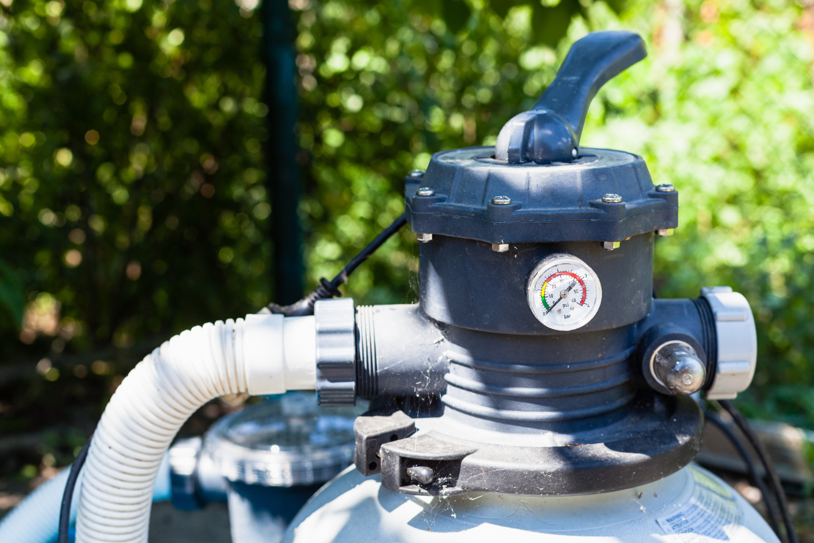 A close up of a pool filter with a hose attached to it.