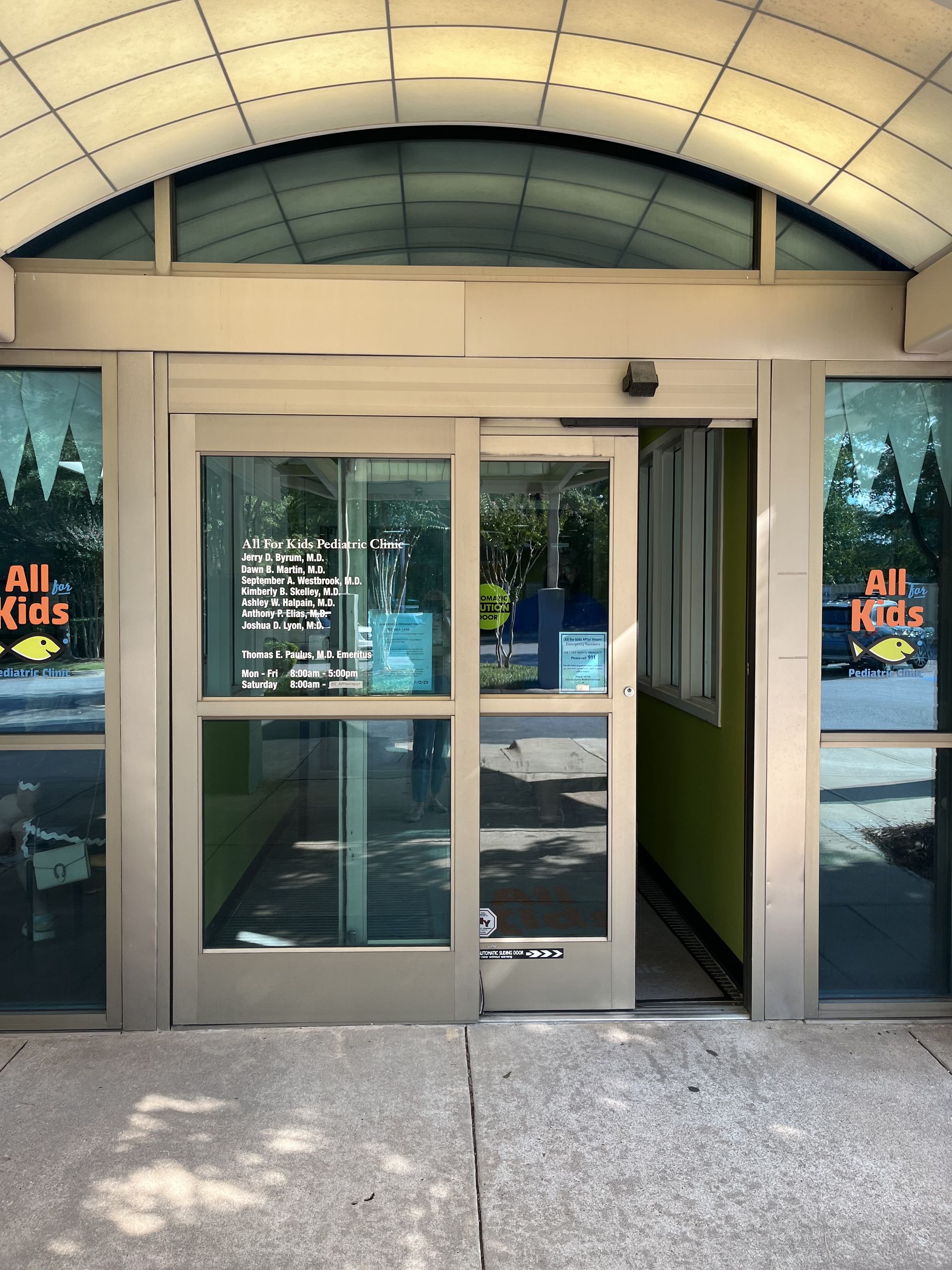 Exterior view of a business entrance with automatic sliding doors.