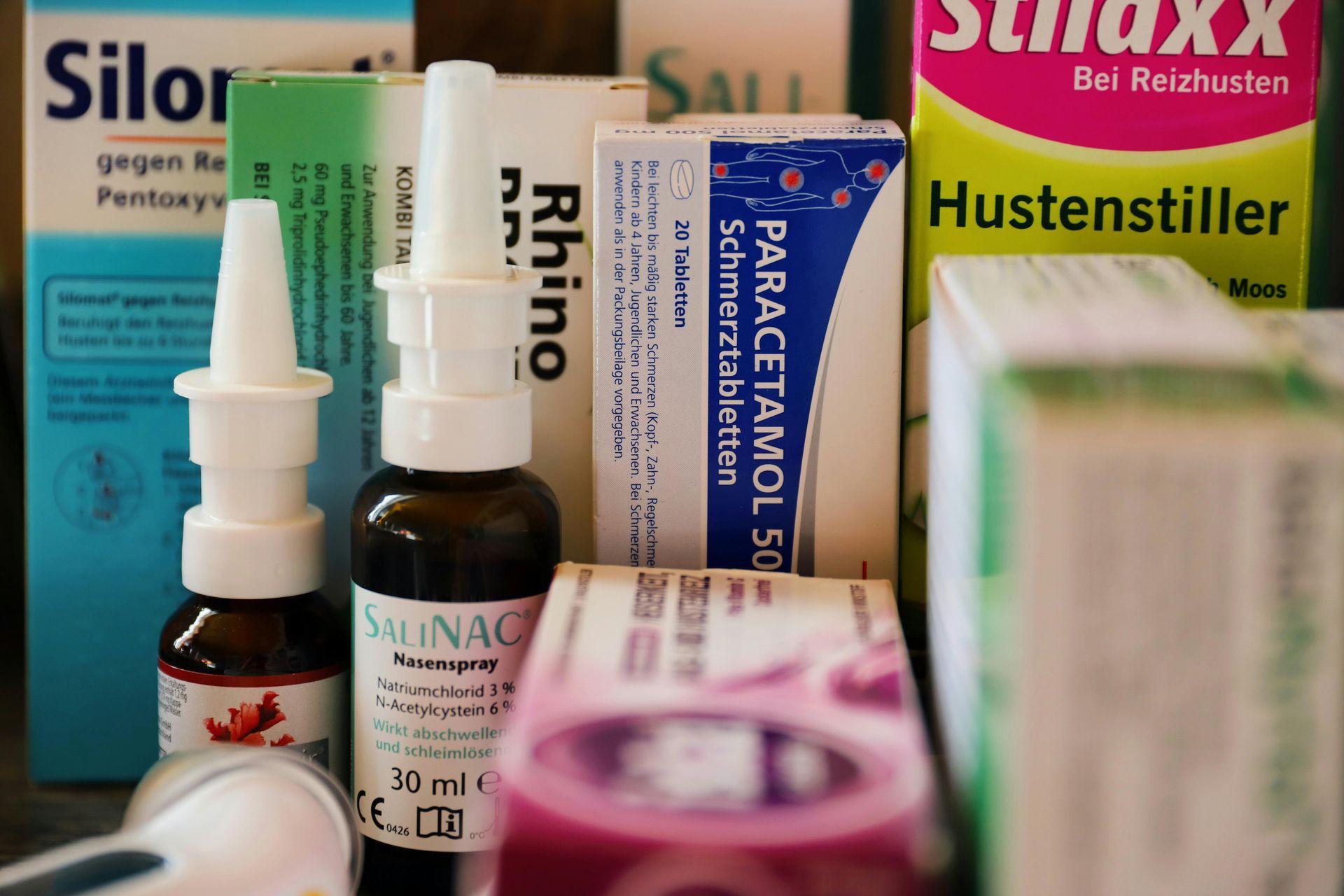 Close-up of various medicine boxes and nasal spray bottles.