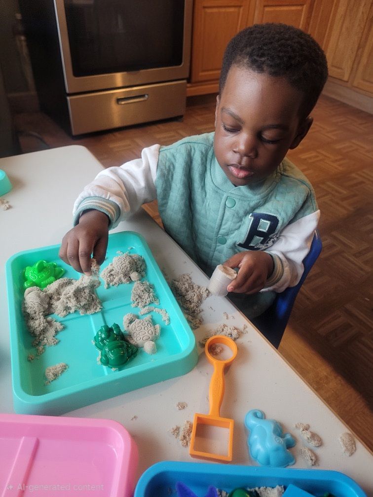 Child playing with kinetic sand at a kitchen table using colorful scoops and molds