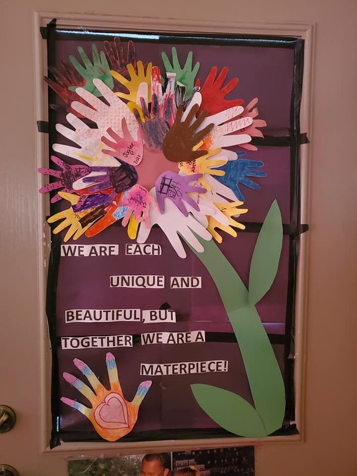 Colorful paper handprint poster with the quote: “We are each unique and beautiful, but together we are a masterpiece.”