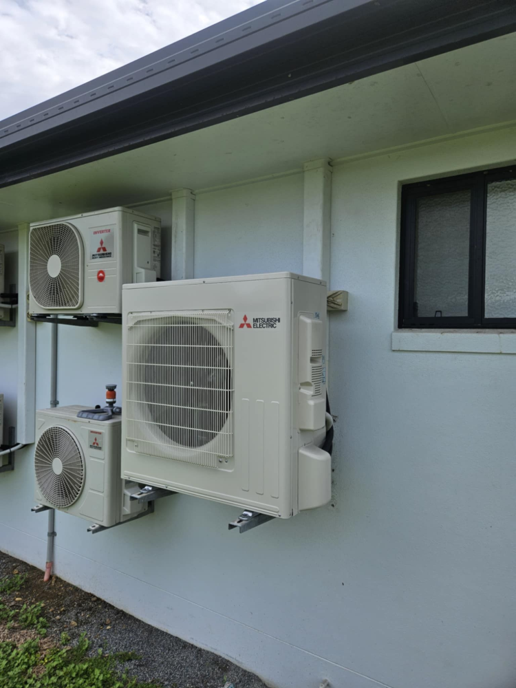 Air conditioning units mounted on the exterior wall of a building— Lit Energy in Seaforth, QLD