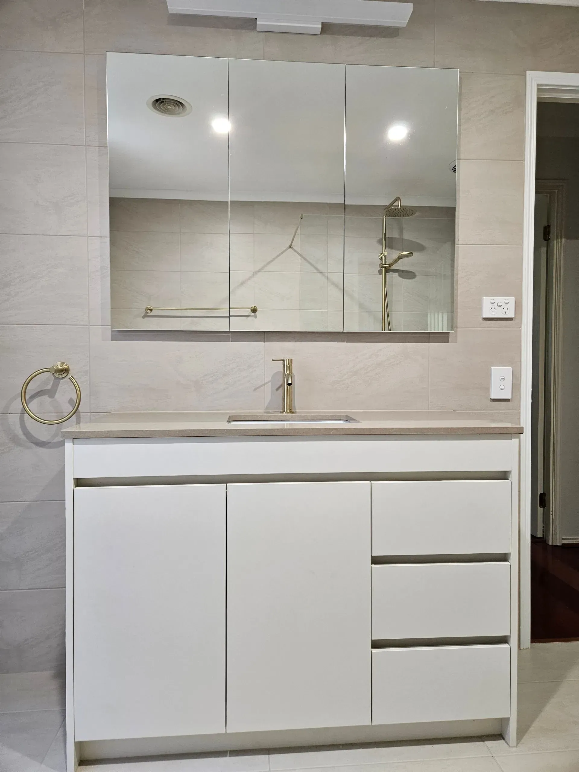 Modern bathroom vanity with mirror, sink, chrome faucet, and light gray tiled walls