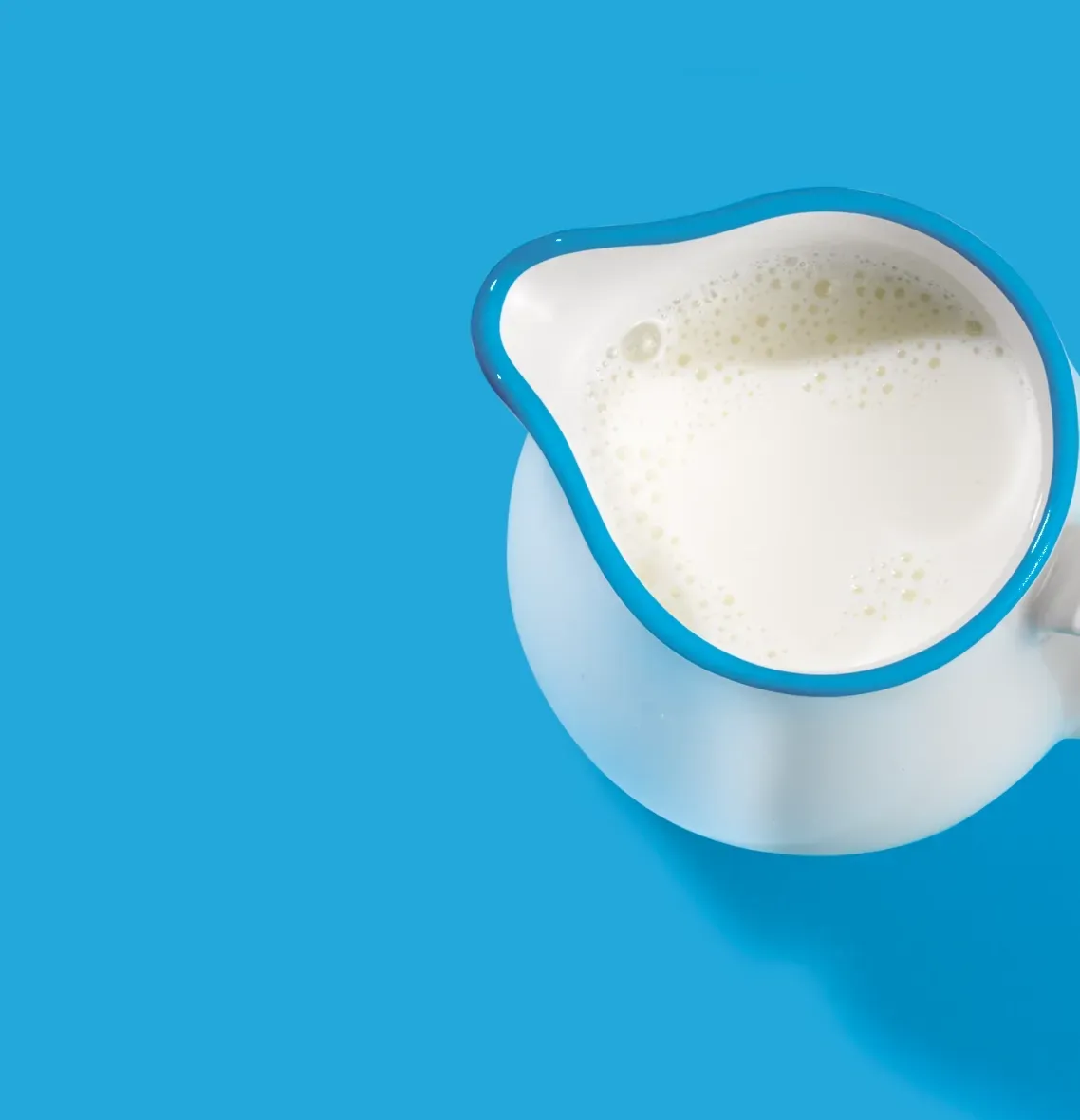 A pitcher of milk on a blue background
