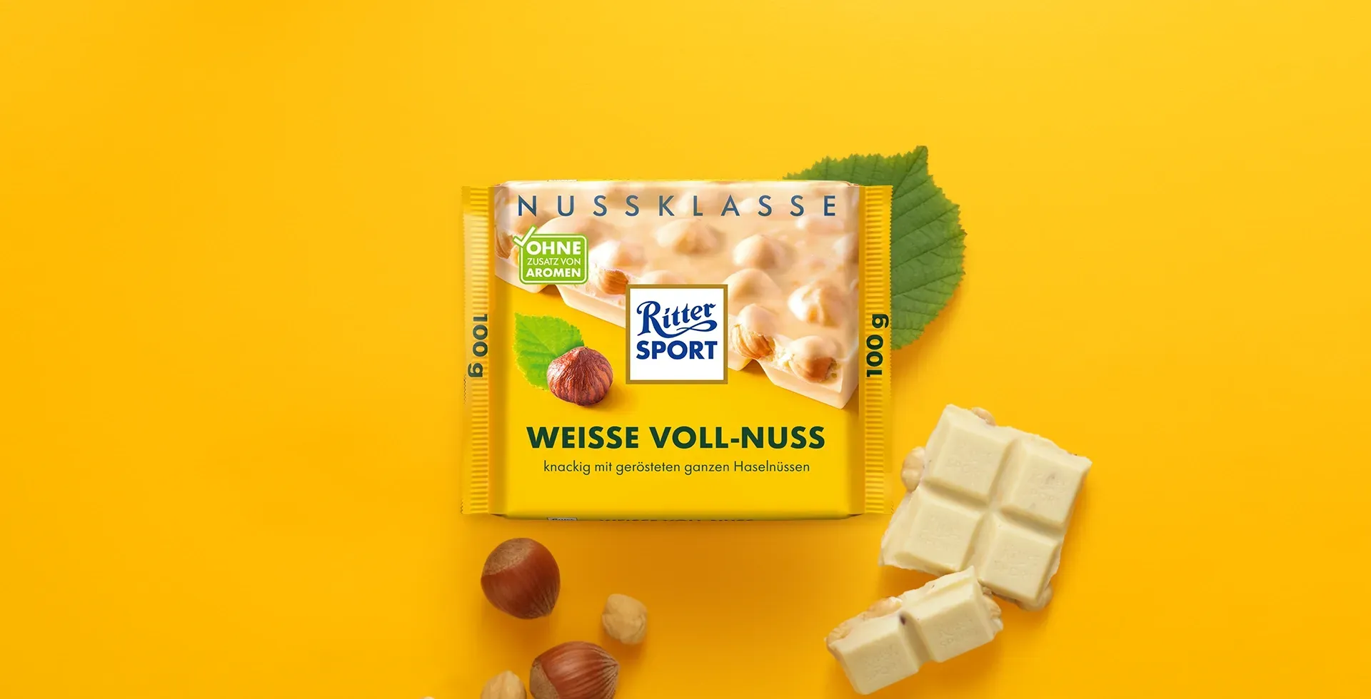 Verpackung einer blauen Schokoladentafel mit Nüssen, Schokoladenstückchen und dem Hinweis „55 % Kakaoanteil“ auf blauem Hintergrund