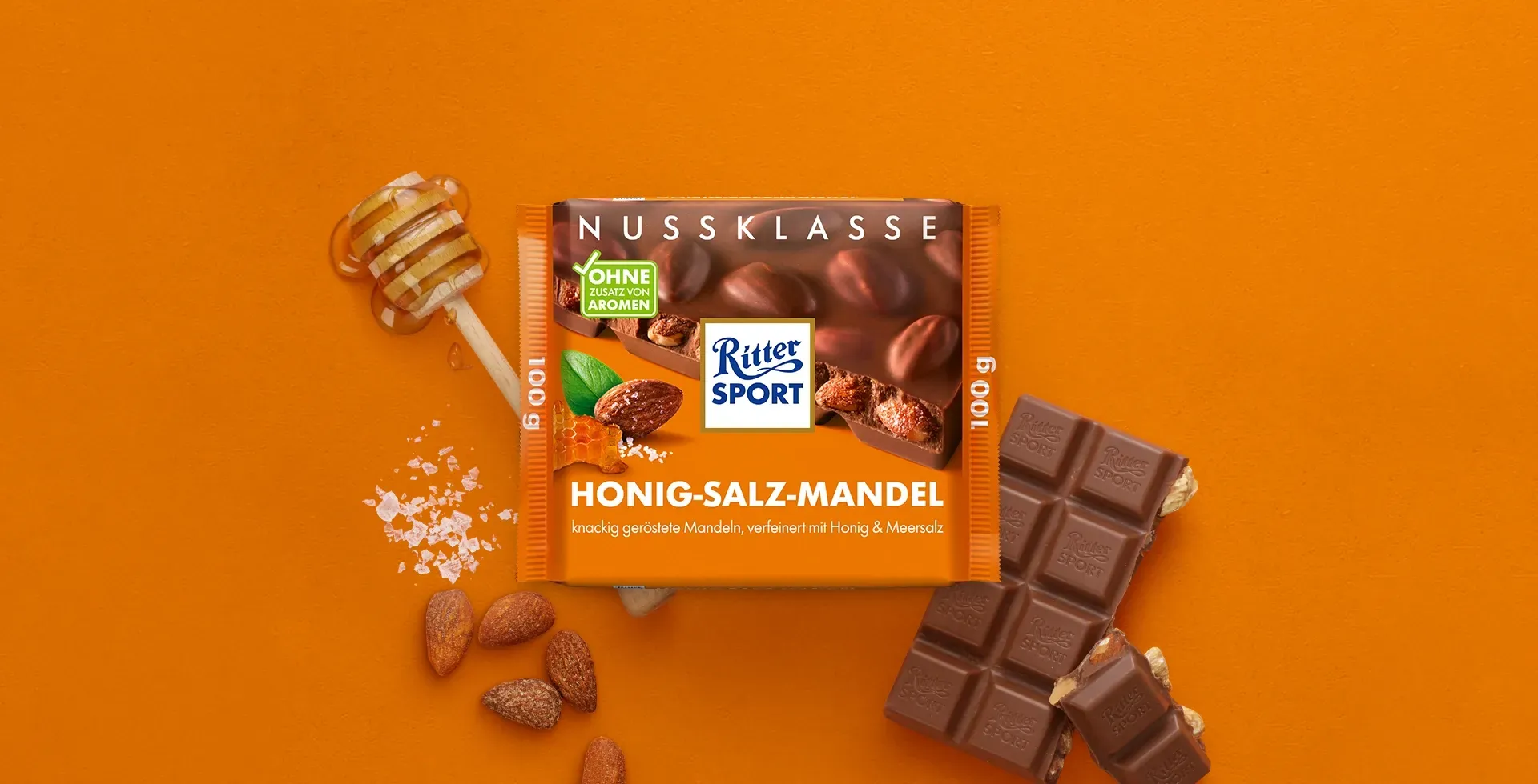 Verpackung einer blauen Schokoladentafel mit Nüssen, Schokoladenstückchen und dem Hinweis „55 % Kakaoanteil“ auf blauem Hintergrund