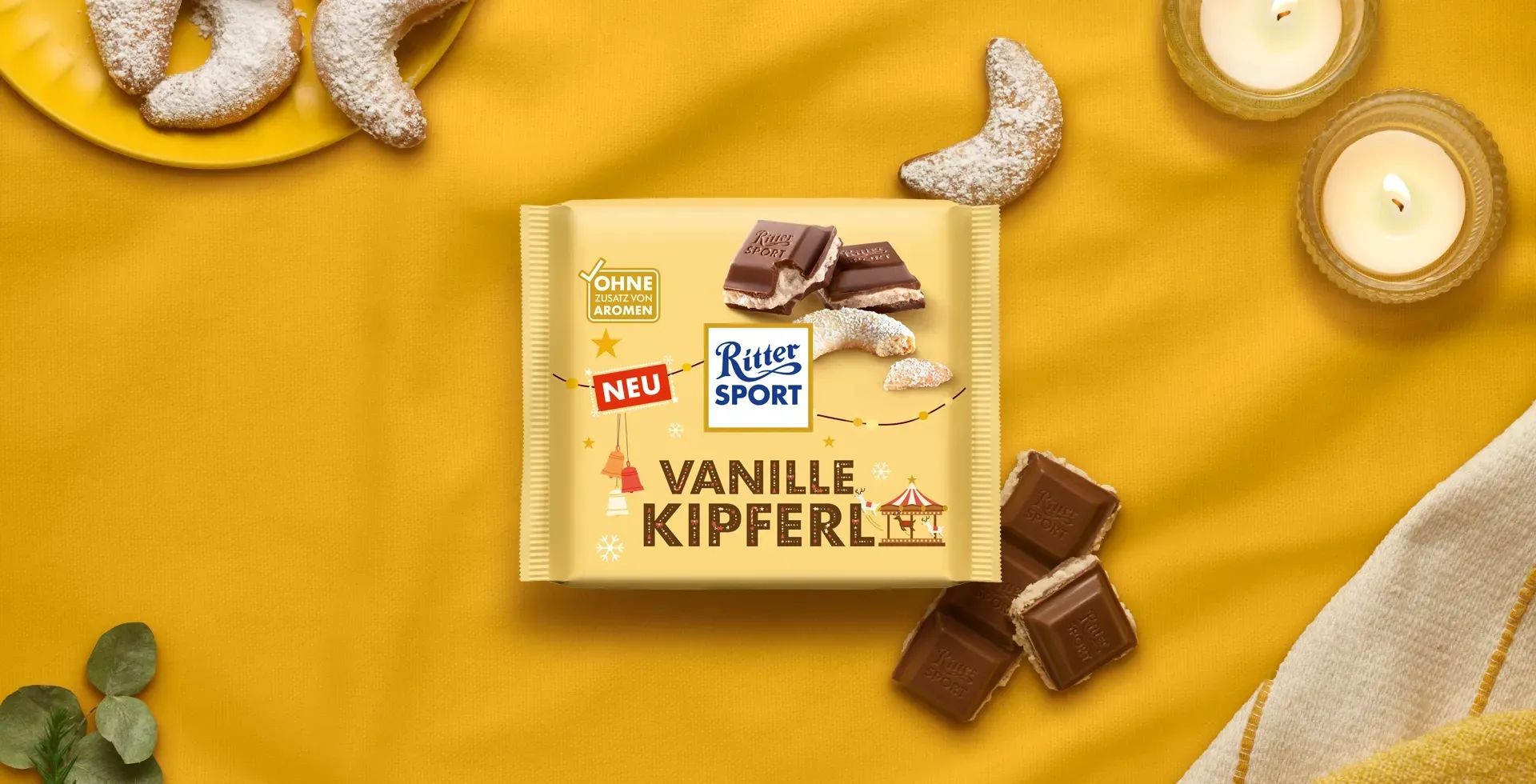 Verpackung einer blauen Schokoladentafel mit Nüssen, Schokoladenstückchen und dem Hinweis „55 % Kakaoanteil“ auf blauem Hintergrund