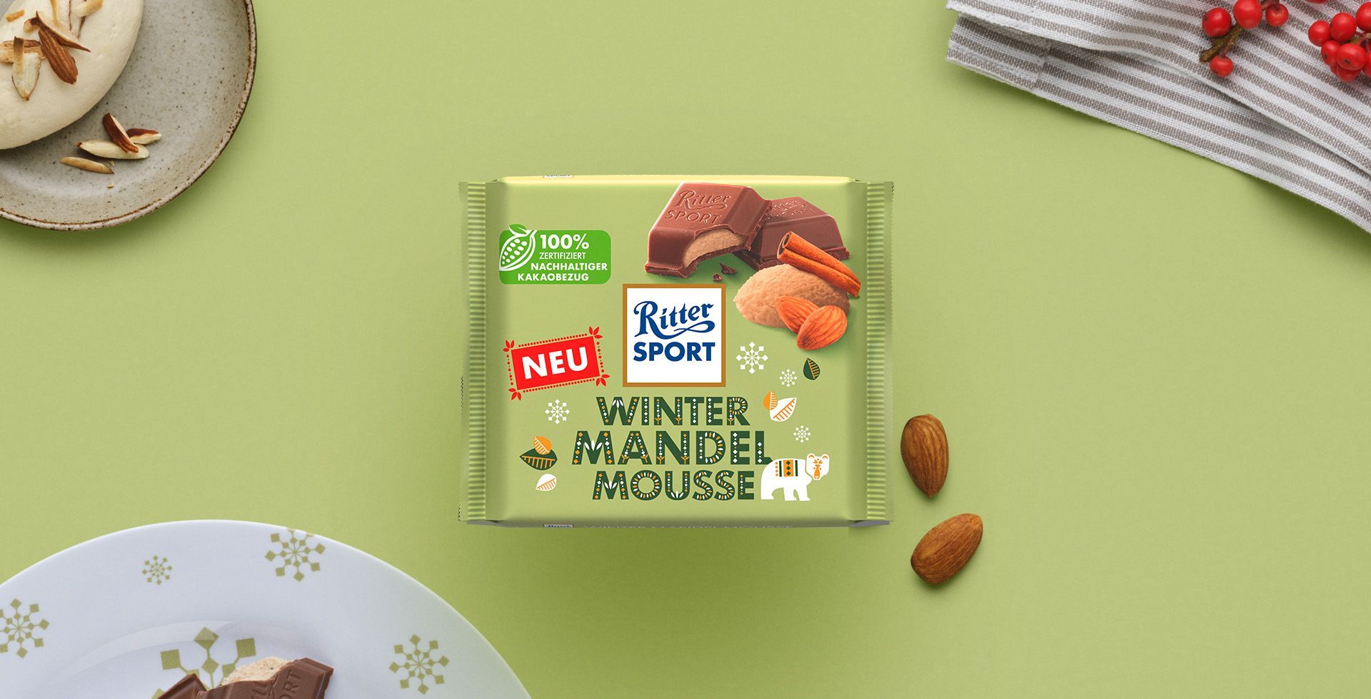Verpackung einer blauen Schokoladentafel mit Nüssen, Schokoladenstückchen und dem Hinweis „55 % Kakaoanteil“ auf blauem Hintergrund