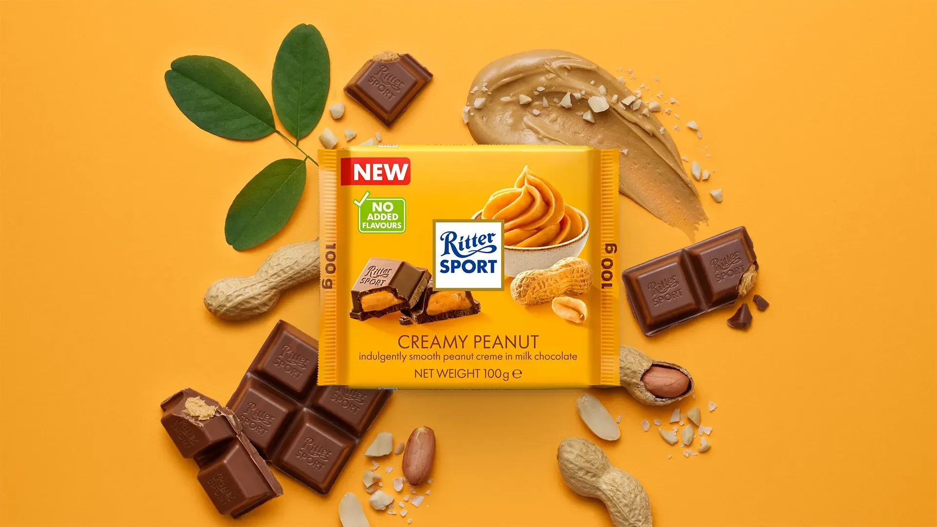Ritter Sport chocolate bar packaging with cocoa beans, broken chocolate, and milk on a blue background.