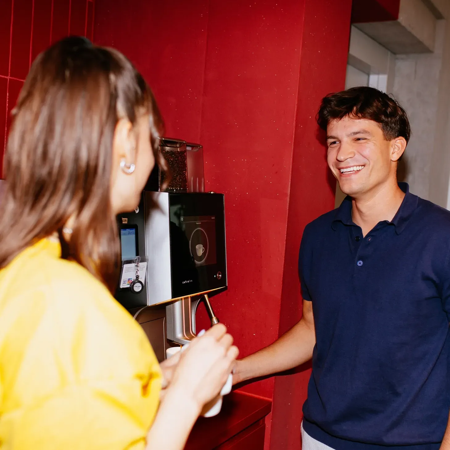 A man in a blue shirt is talking to a woman in a yellow shirt