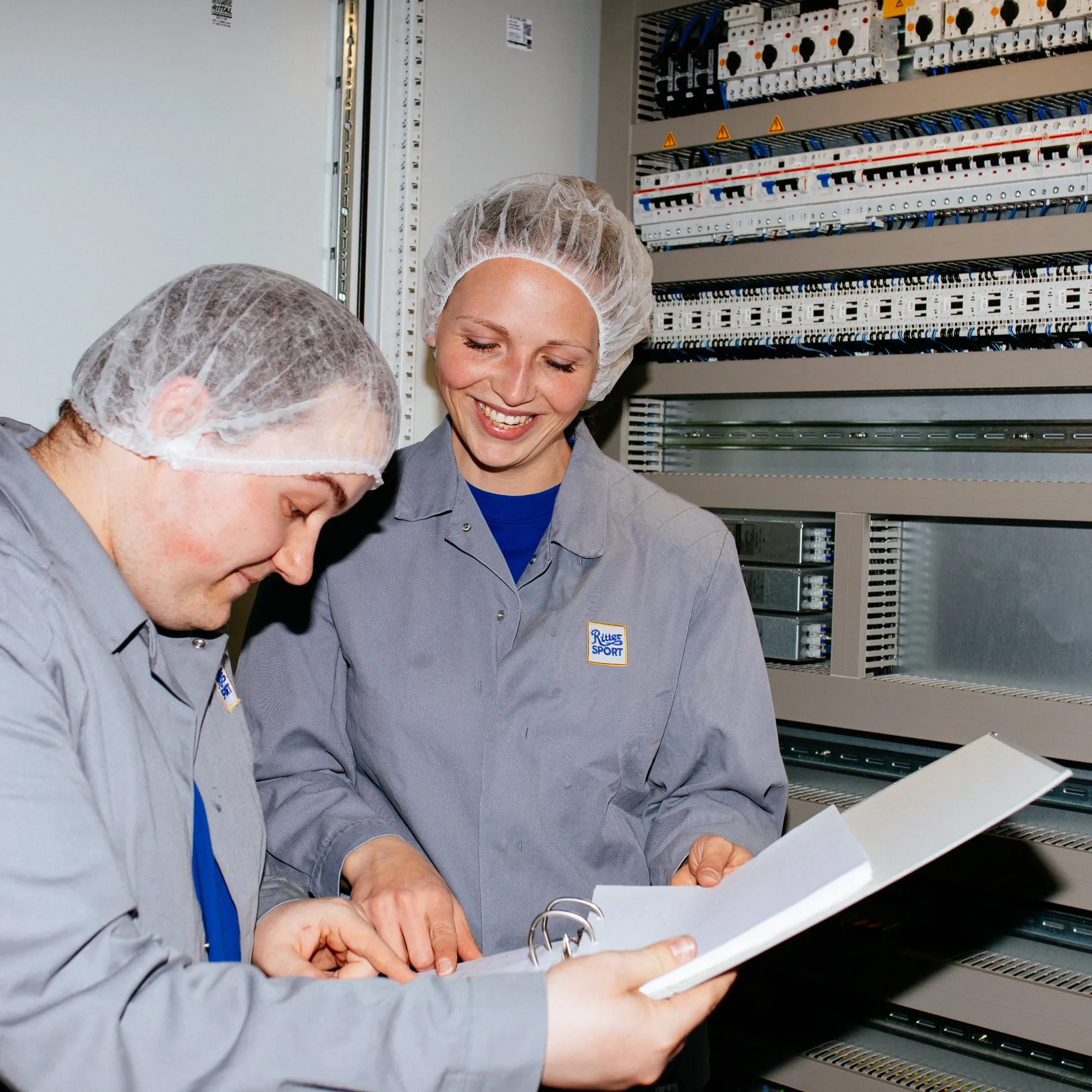A man and a woman are looking at a binder