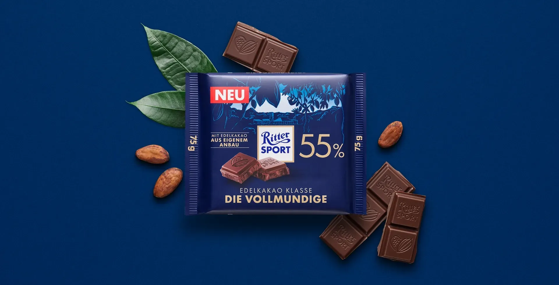 Verpackung einer blauen Schokoladentafel mit Nüssen, Schokoladenstückchen und dem Hinweis „55 % Kakaoanteil“ auf blauem Hintergrund