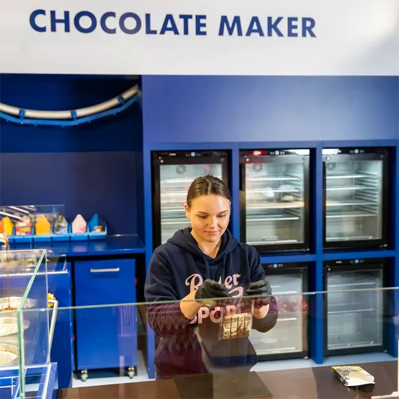 Frau in Ritter Sport Pulli macht eine Schokolade von Hand