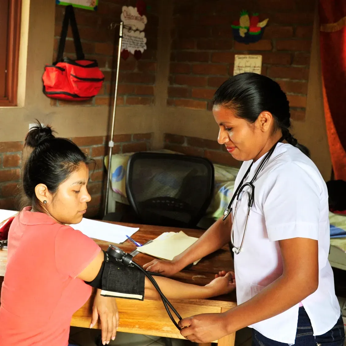 a nurse is checking the blood pressure of a woman