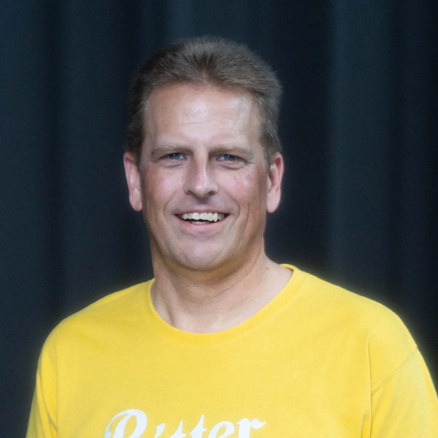 A man wearing a yellow shirt