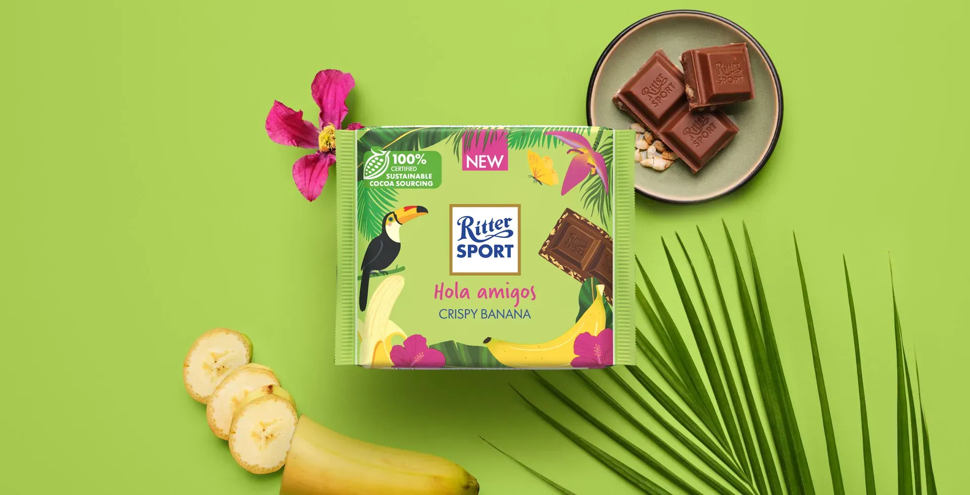 Ritter Sport chocolate bar packaging with cocoa beans, broken chocolate, and milk on a blue background.