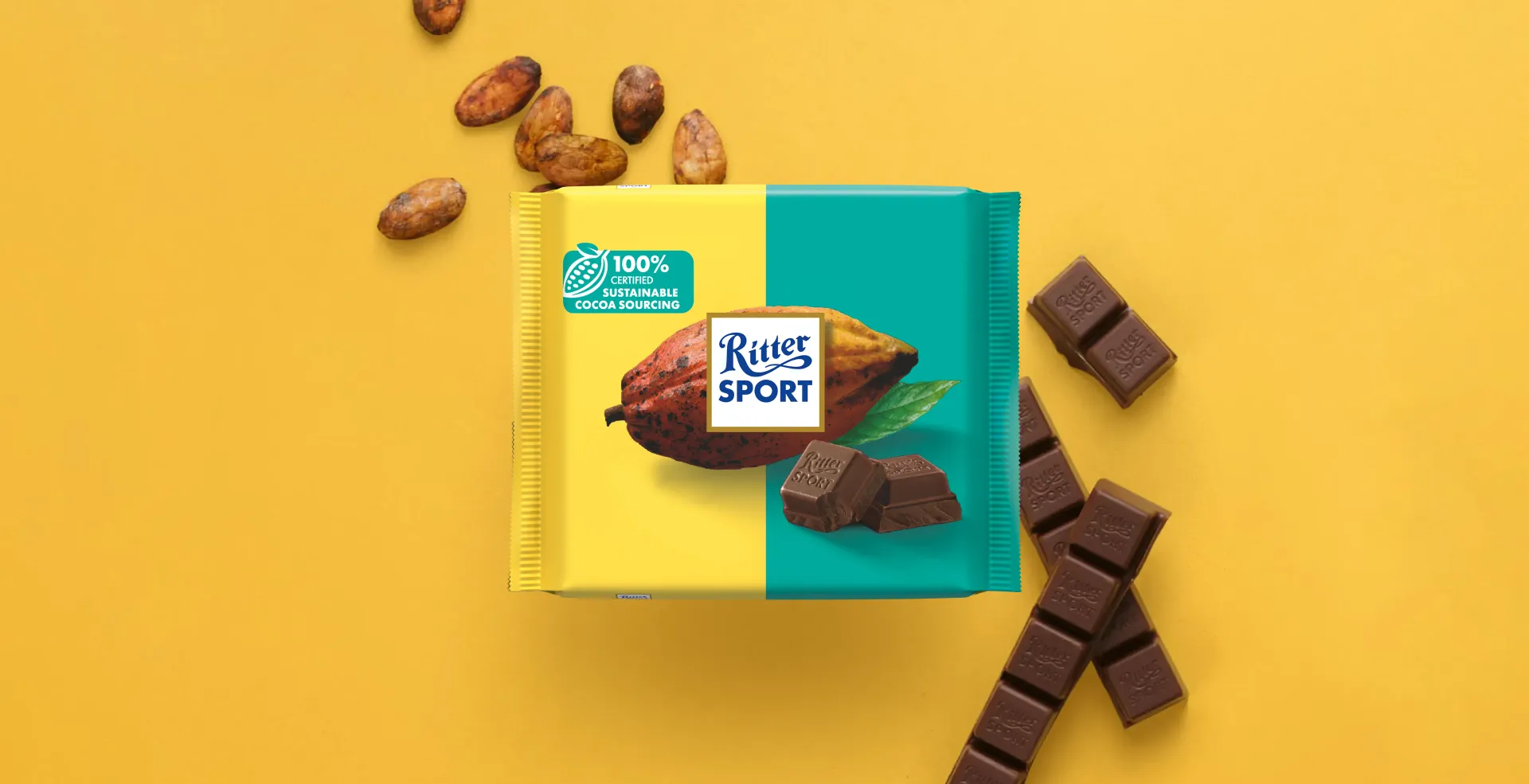 Ritter Sport chocolate bar packaging with cocoa beans, broken chocolate, and milk on a blue background.