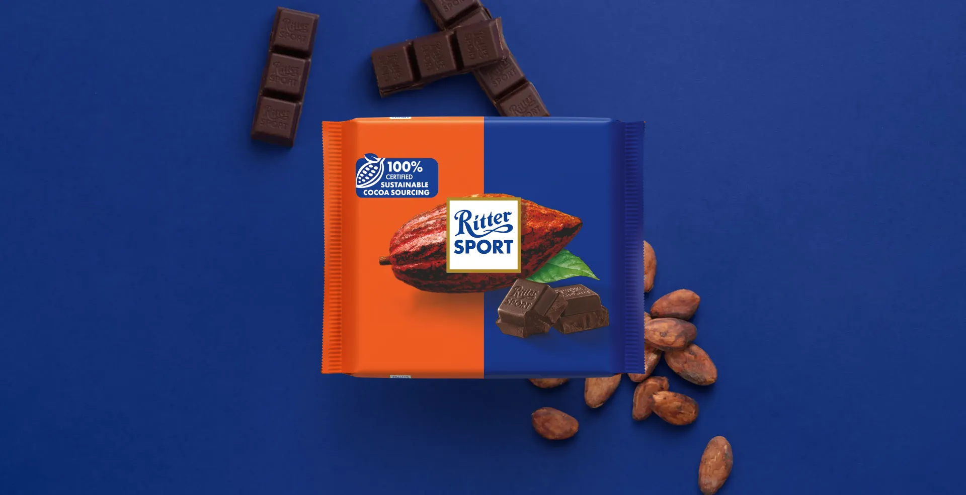 Ritter Sport chocolate bar packaging with cocoa beans, broken chocolate, and milk on a blue background.