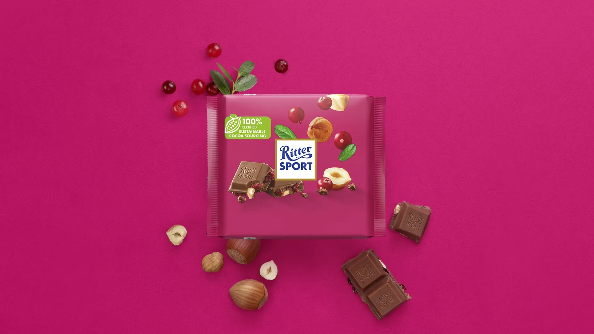 Ritter Sport chocolate bar packaging with cocoa beans, broken chocolate, and milk on a blue background.