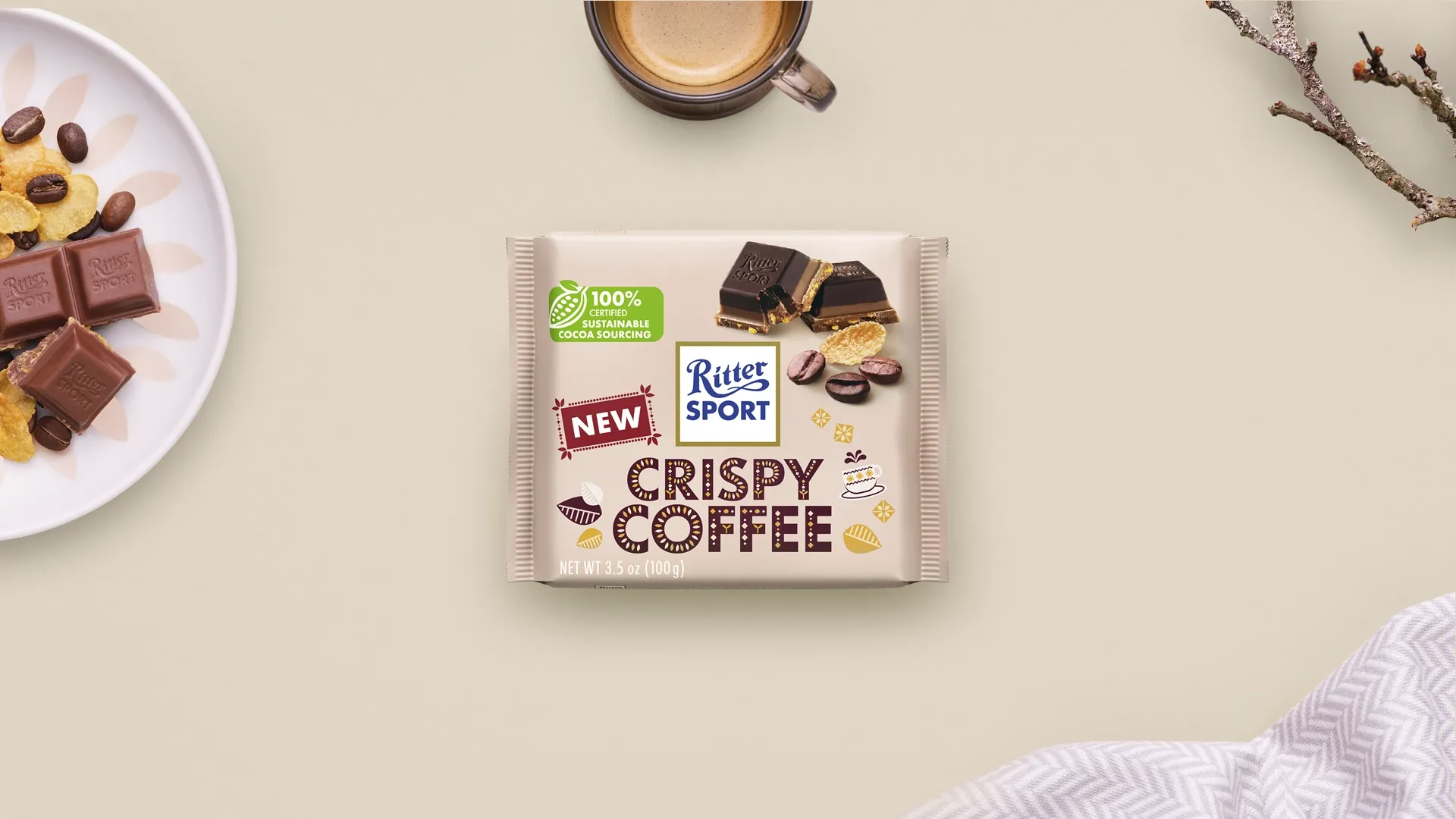 Ritter Sport chocolate bar packaging with cocoa beans, broken chocolate, and milk on a blue background.