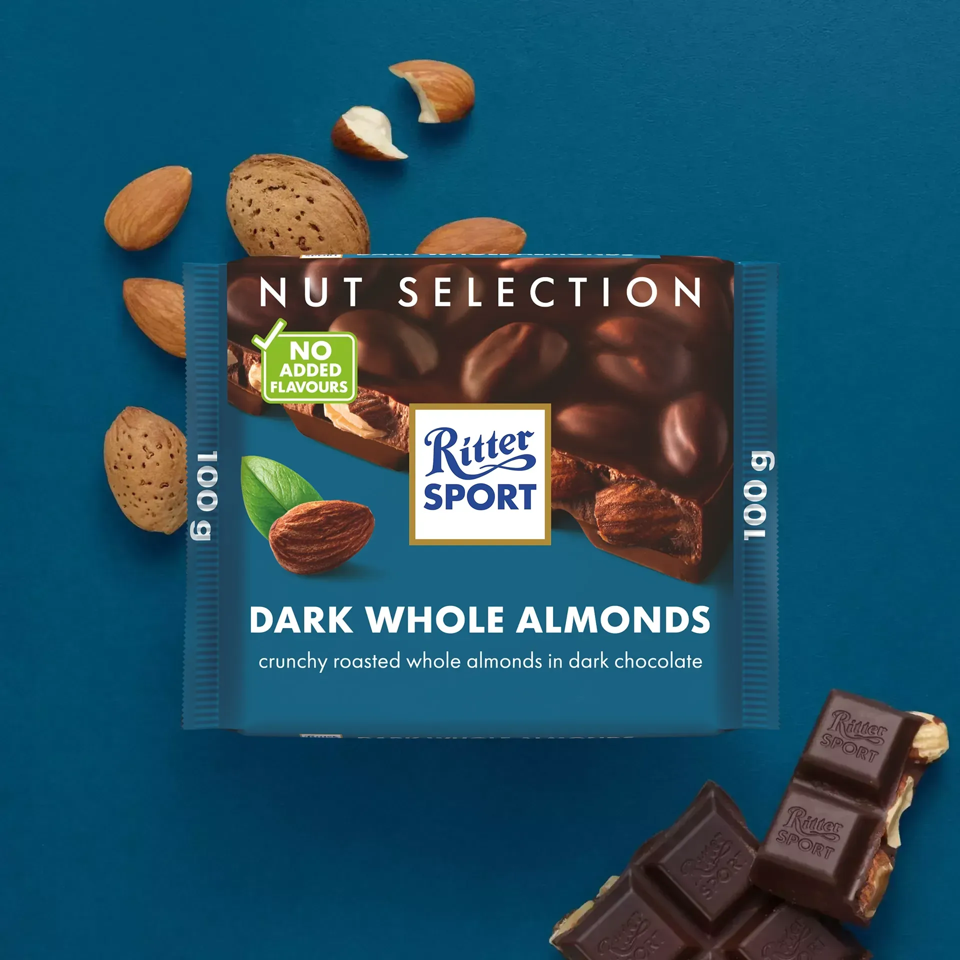 Ritter Sport chocolate bar with almonds on a blue surface, scattered almonds nearby, and a partially eaten bar.