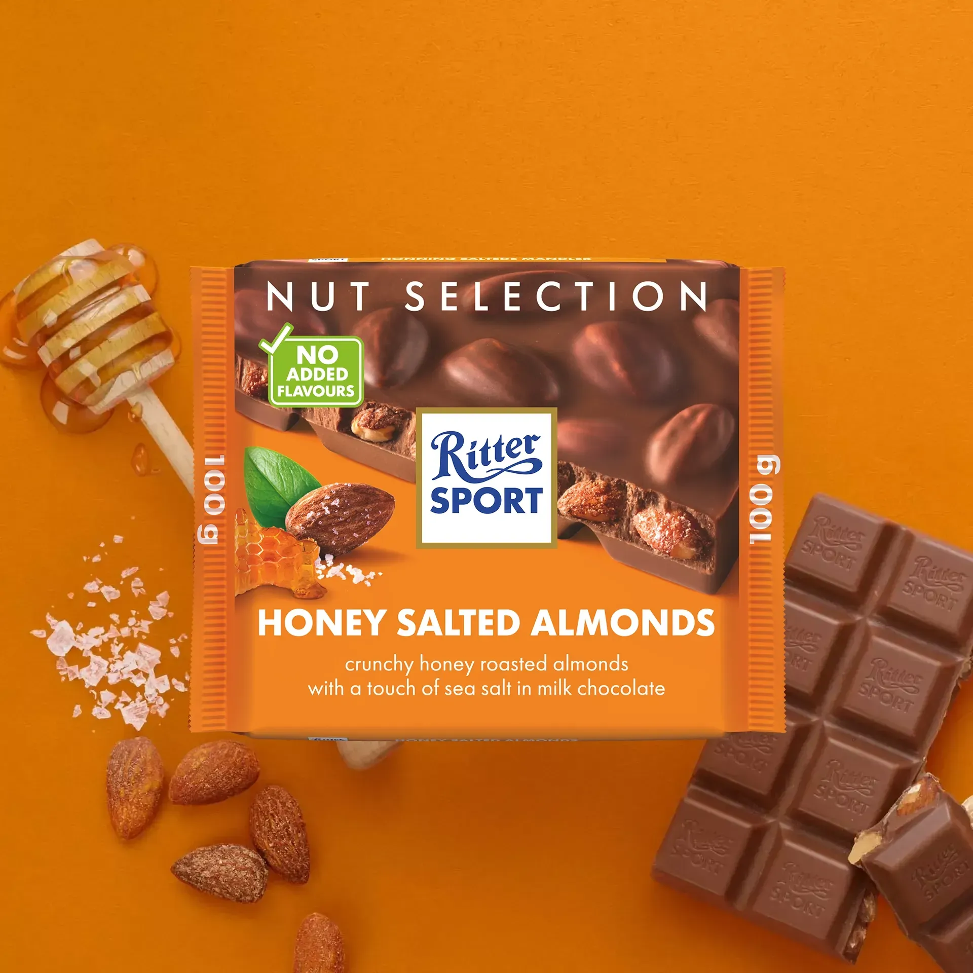 Ritter Sport Nut Selection bar. Milk chocolate with honey sea-salt almonds. Orange background with almonds and a honey stick.