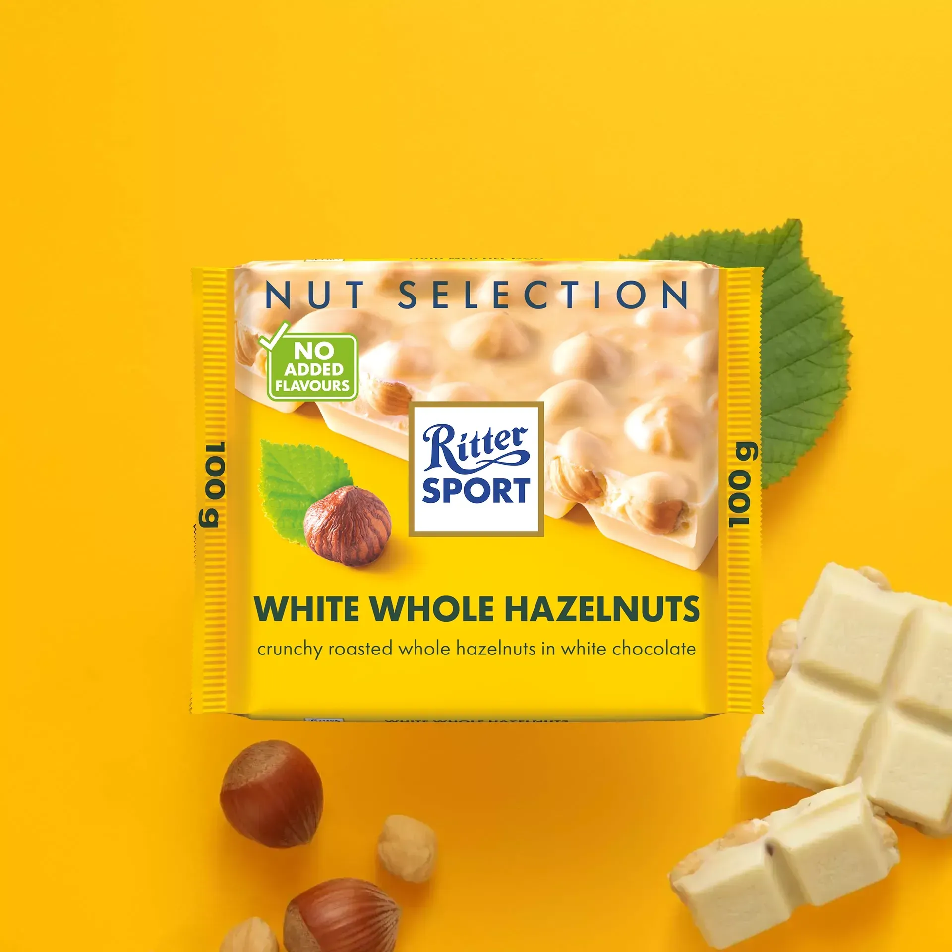 Ritter Sport white chocolate bar with hazelnuts on yellow background; includes hazelnuts and leaf.