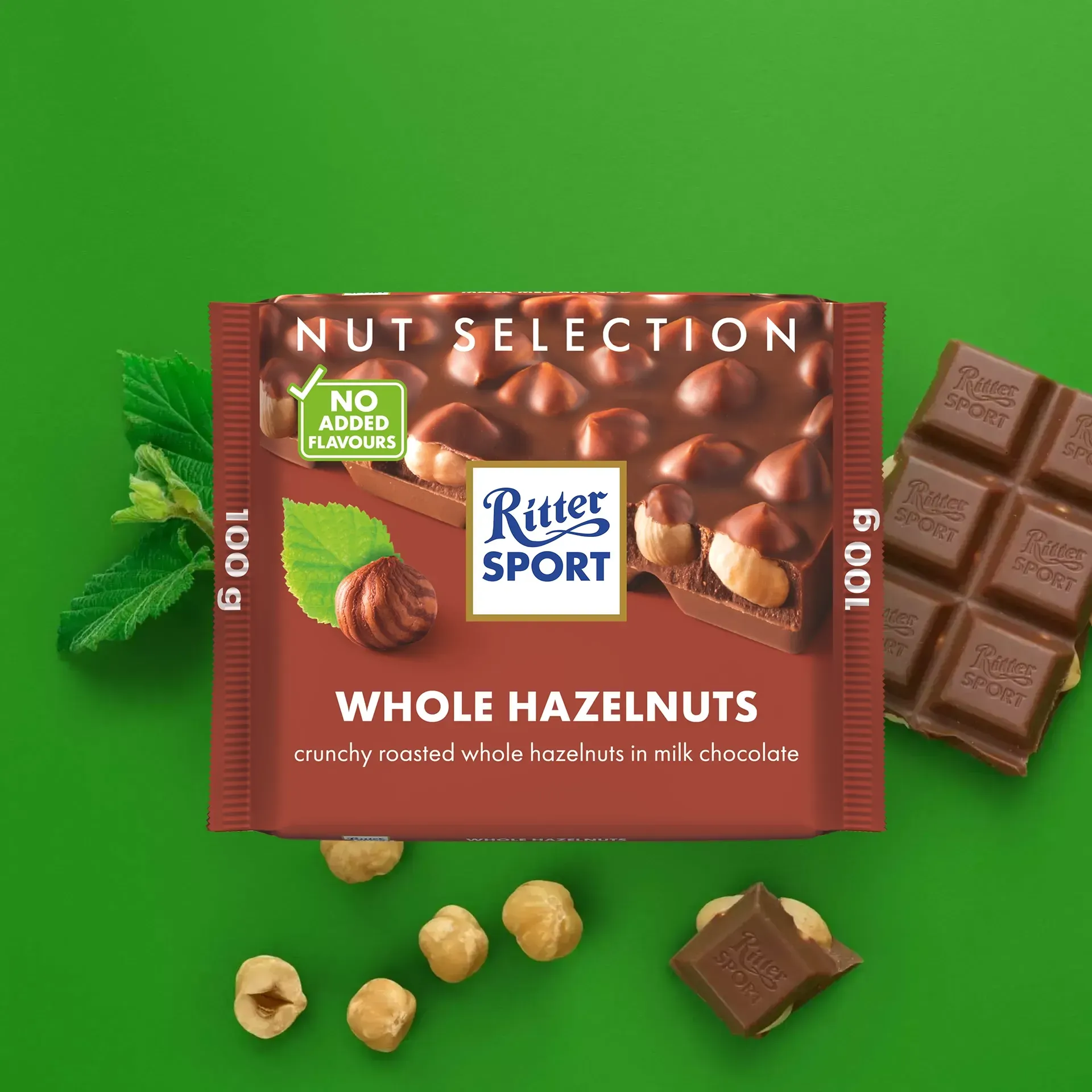 Ritter Sport chocolate bar with whole hazelnuts; package and pieces on green background.