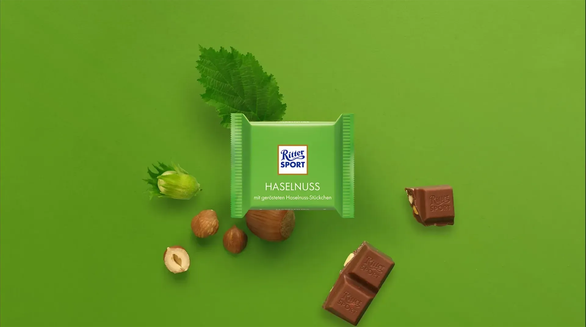 Grüne, pyramidenförmige Geschenkbox mit festlicher roter und goldener Dekoration auf dunkelgrünem Hintergrund. 
Bild wurde mithilfe von KI erstellt.