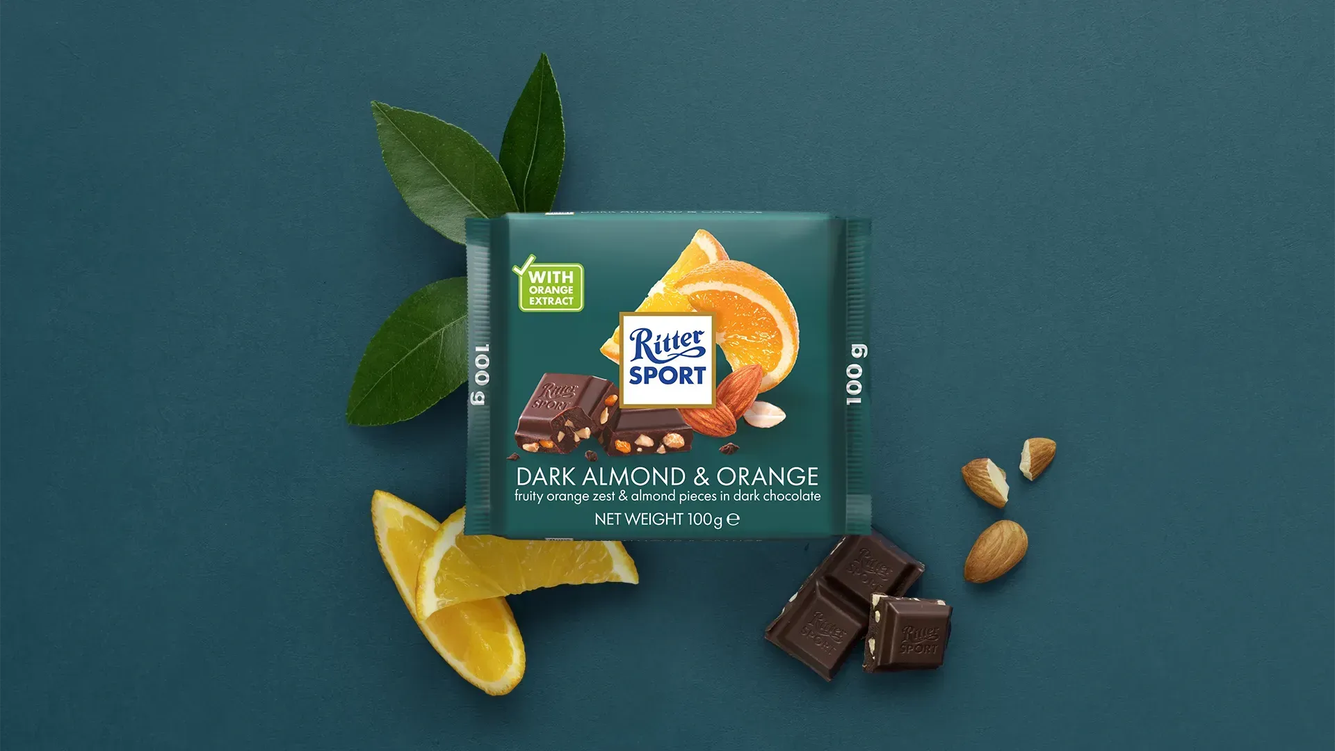 Ritter Sport chocolate bar packaging with cocoa beans, broken chocolate, and milk on a blue background.