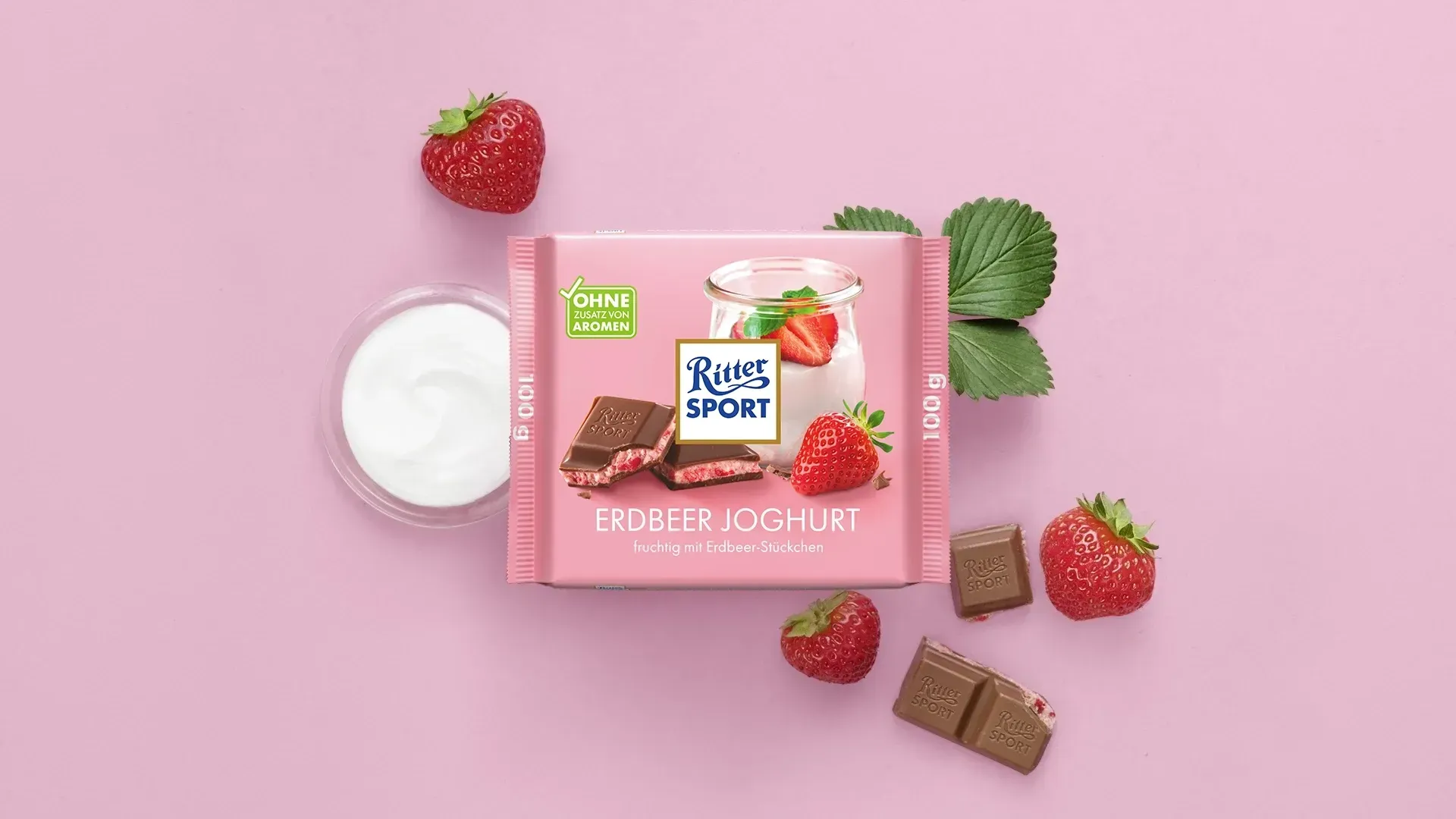 Verpackung einer blauen Schokoladentafel mit Nüssen, Schokoladenstückchen und dem Hinweis „55 % Kakaoanteil“ auf blauem Hintergrund