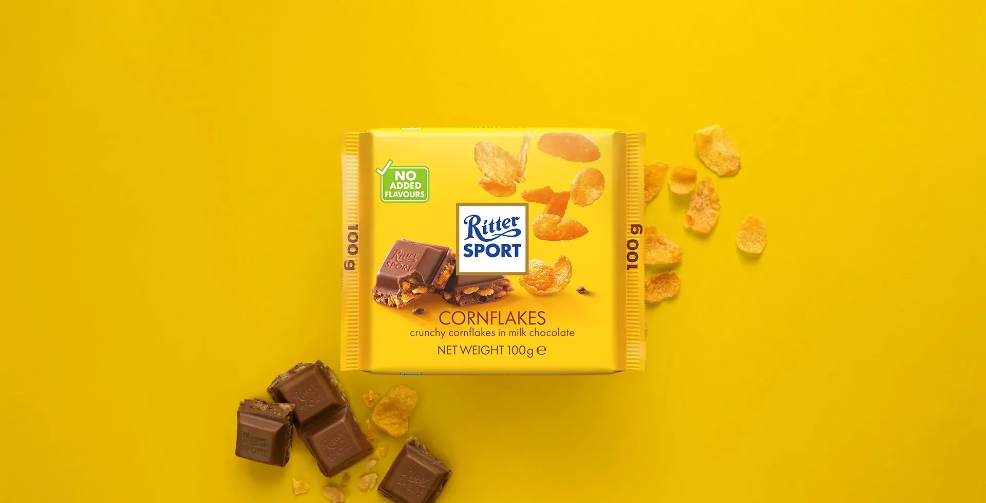 Ritter Sport chocolate bar packaging with cocoa beans, broken chocolate, and milk on a blue background.