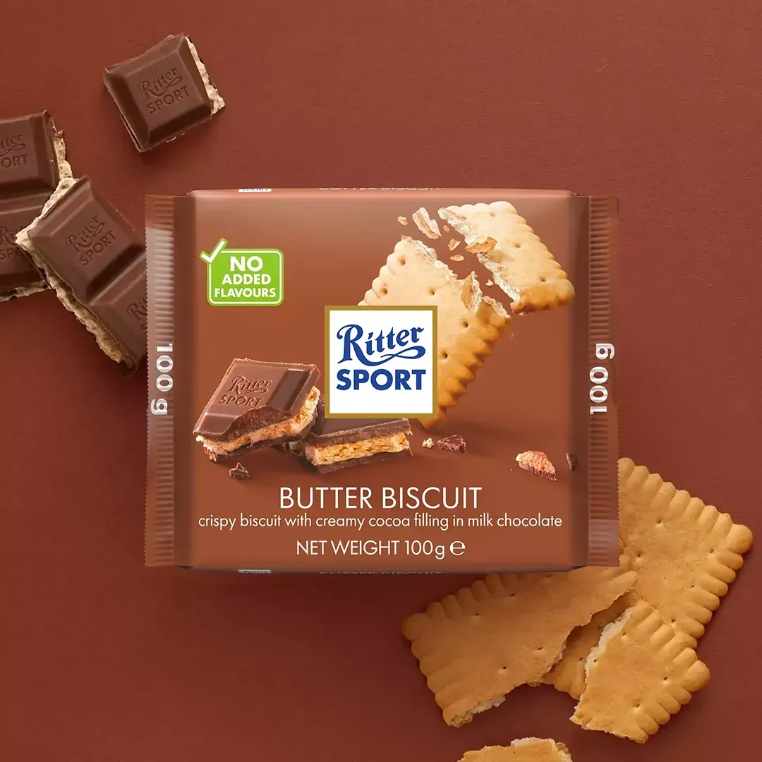Ritter Sport Butter Biscuit chocolate bar on a brown background with pieces and biscuits