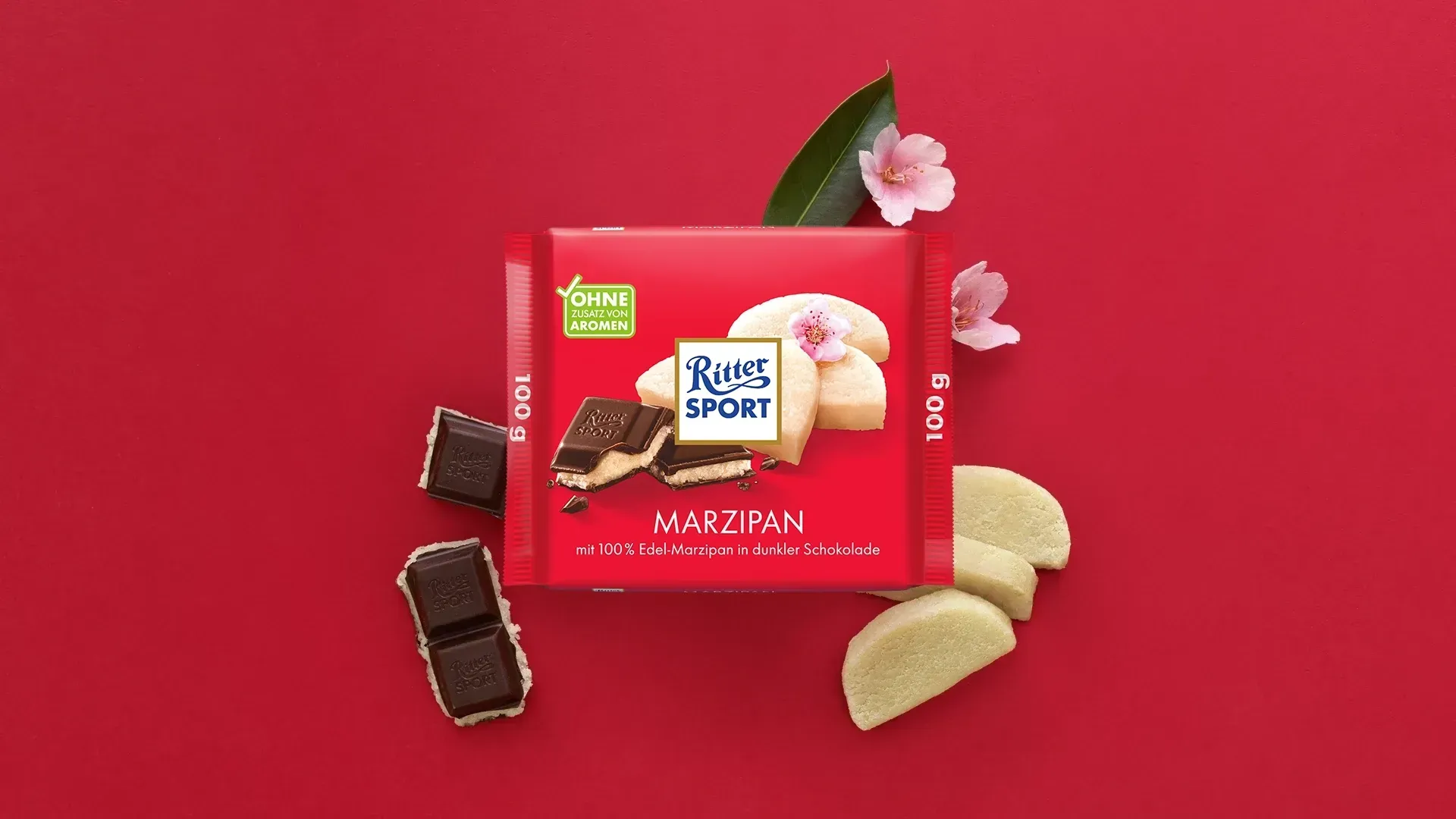 Verpackung einer blauen Schokoladentafel mit Nüssen, Schokoladenstückchen und dem Hinweis „55 % Kakaoanteil“ auf blauem Hintergrund