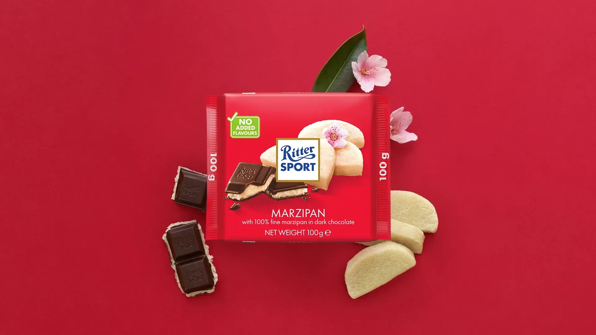 Ritter Sport chocolate bar packaging with cocoa beans, broken chocolate, and milk on a blue background.