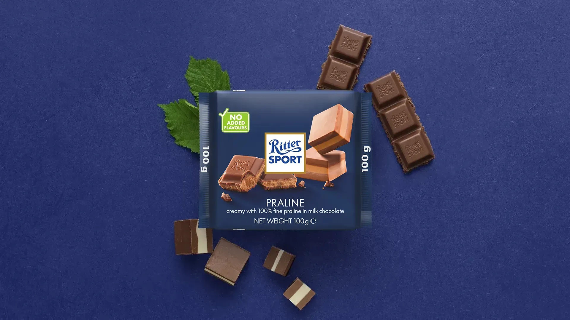 Ritter Sport chocolate bar packaging with cocoa beans, broken chocolate, and milk on a blue background.