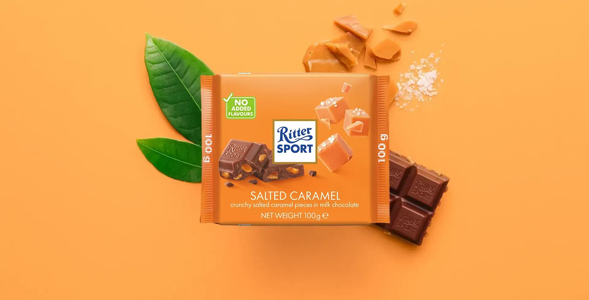 Ritter Sport chocolate bar packaging with cocoa beans, broken chocolate, and milk on a blue background.
