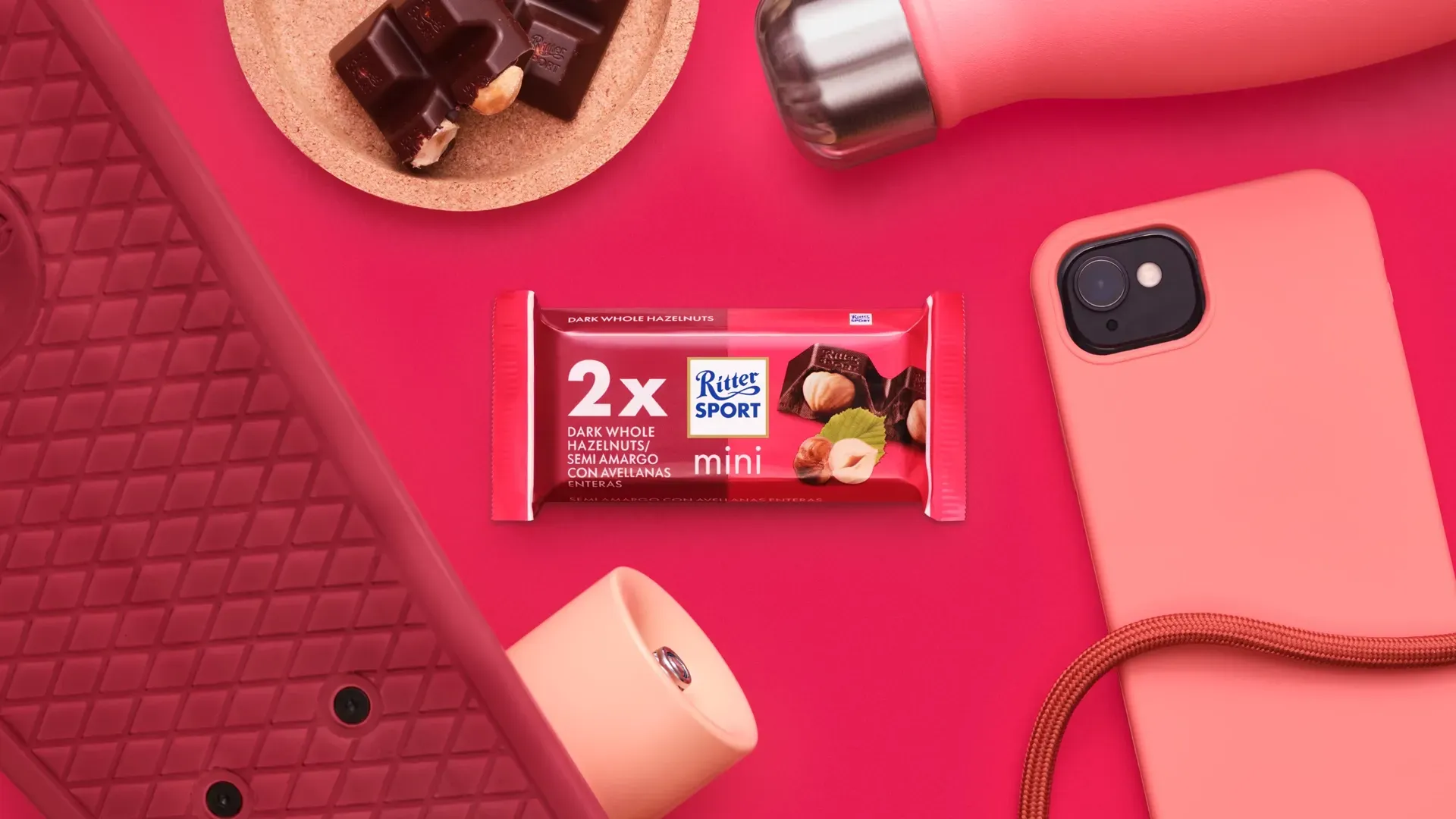 Ritter Sport chocolate bar packaging with cocoa beans, broken chocolate, and milk on a blue background.