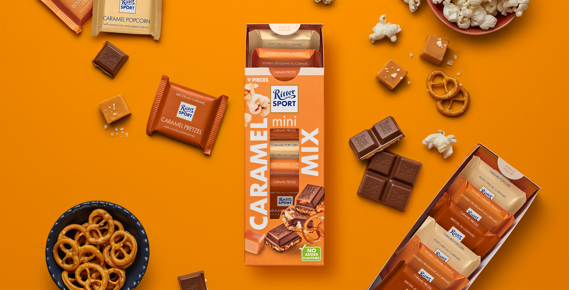 Ritter Sport chocolate bar packaging with cocoa beans, broken chocolate, and milk on a blue background.