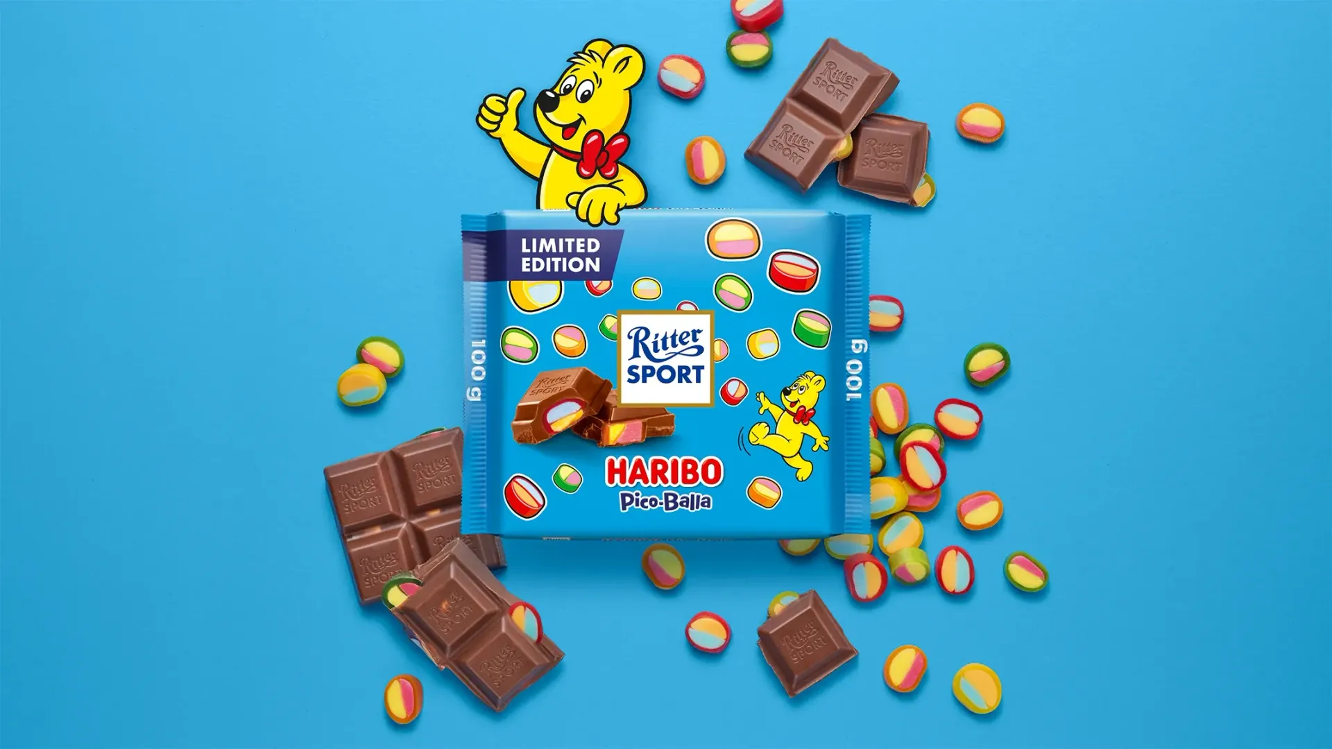 Verpackung einer blauen Schokoladentafel mit Nüssen, Schokoladenstückchen und dem Hinweis „55 % Kakaoanteil“ auf blauem Hintergrund