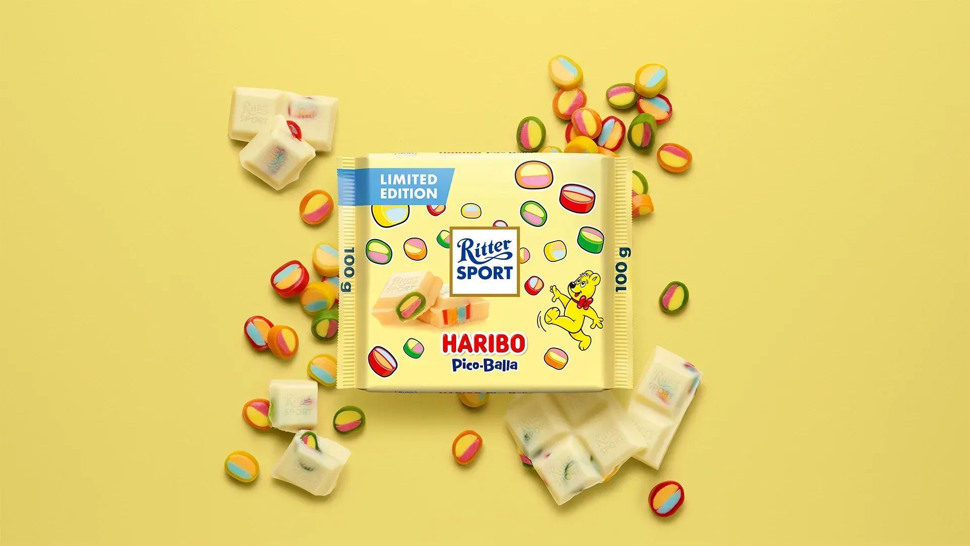 Verpackung einer blauen Schokoladentafel mit Nüssen, Schokoladenstückchen und dem Hinweis „55 % Kakaoanteil“ auf blauem Hintergrund