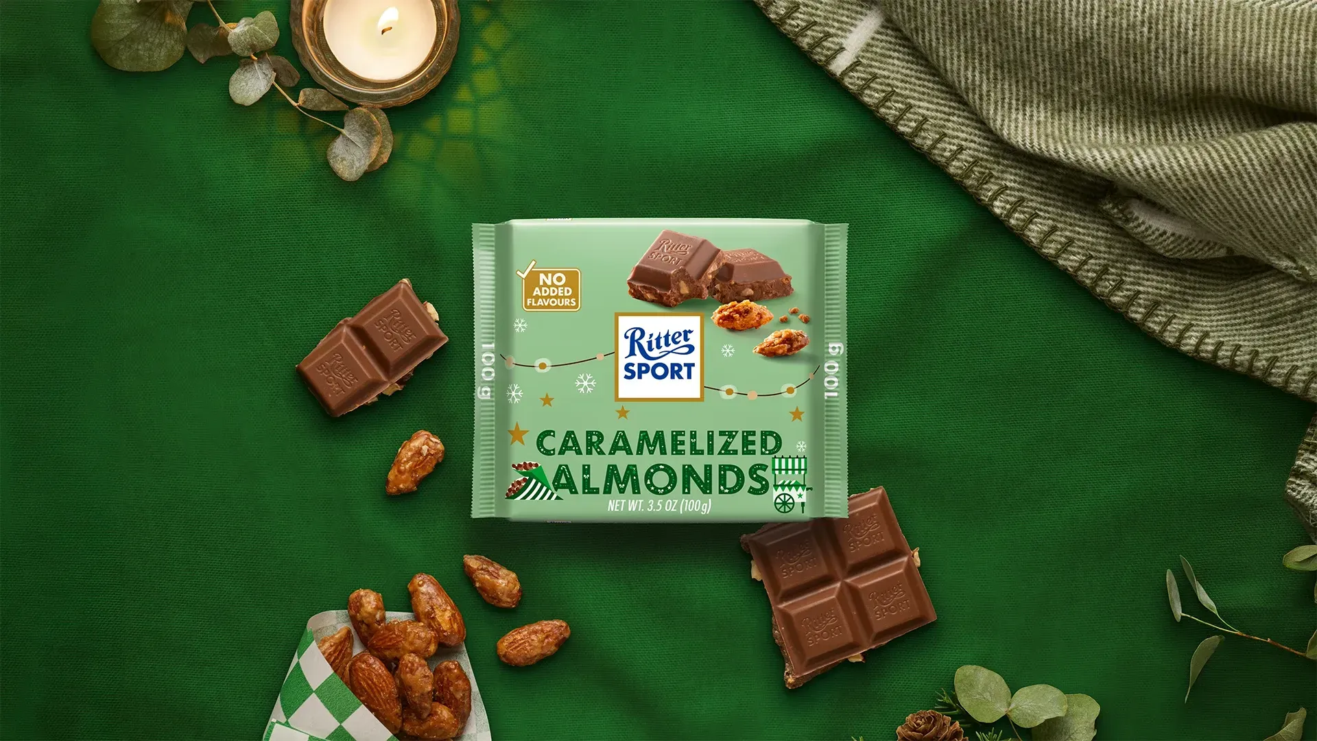 Ritter Sport chocolate bar packaging with cocoa beans, broken chocolate, and milk on a blue background.