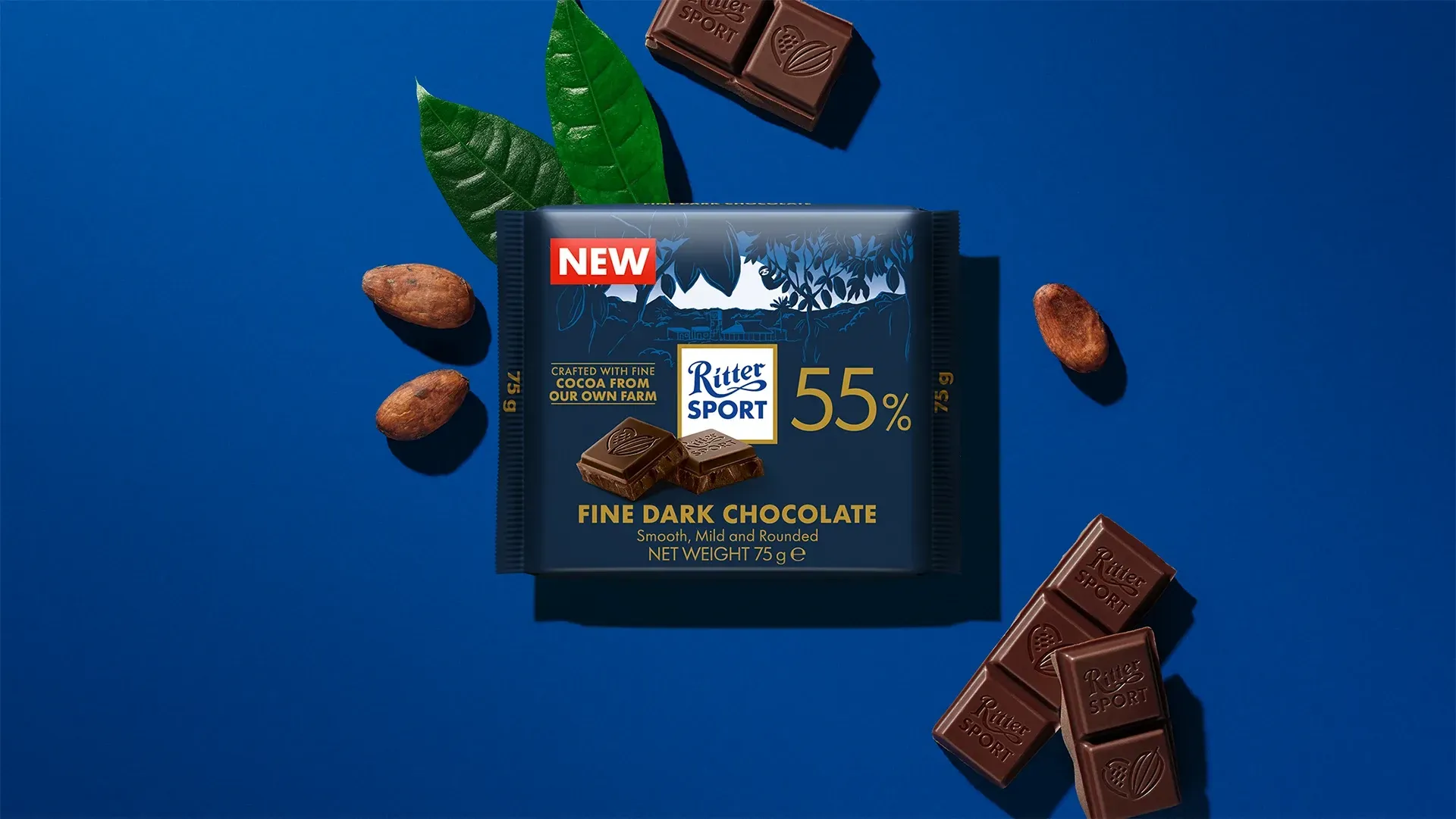 Ritter Sport chocolate bar packaging with cocoa beans, broken chocolate, and milk on a blue background.