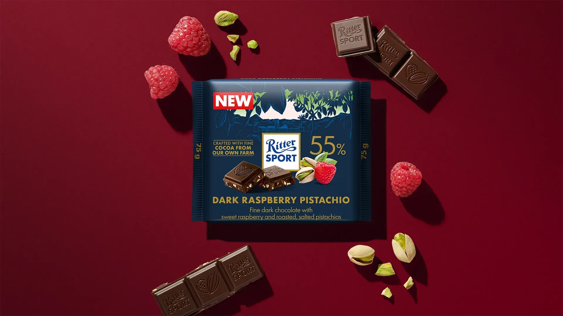 Ritter Sport chocolate bar packaging with cocoa beans, broken chocolate, and milk on a blue background.