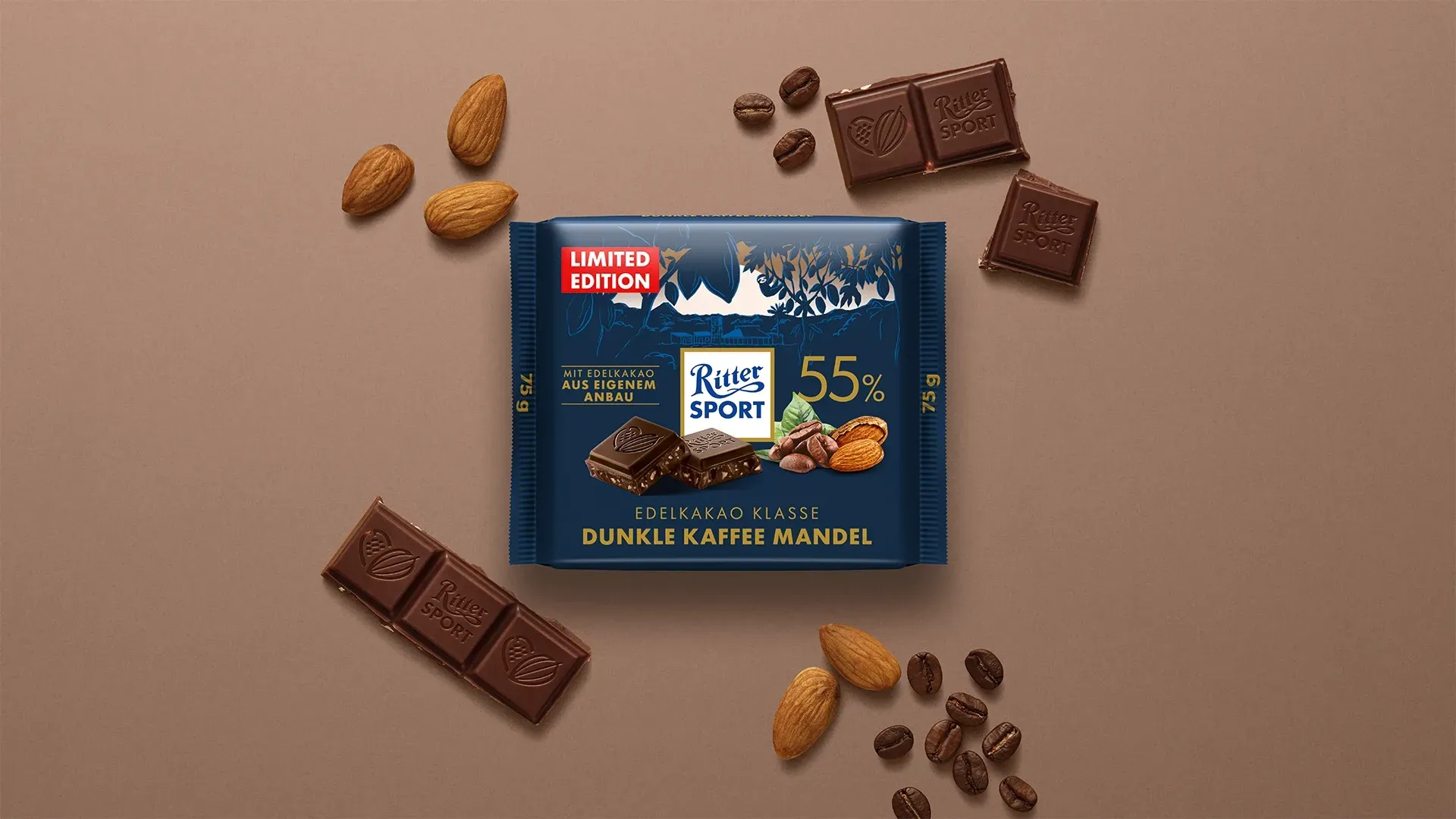 Verpackung einer blauen Schokoladentafel mit Nüssen, Schokoladenstückchen und dem Hinweis „55 % Kakaoanteil“ auf blauem Hintergrund