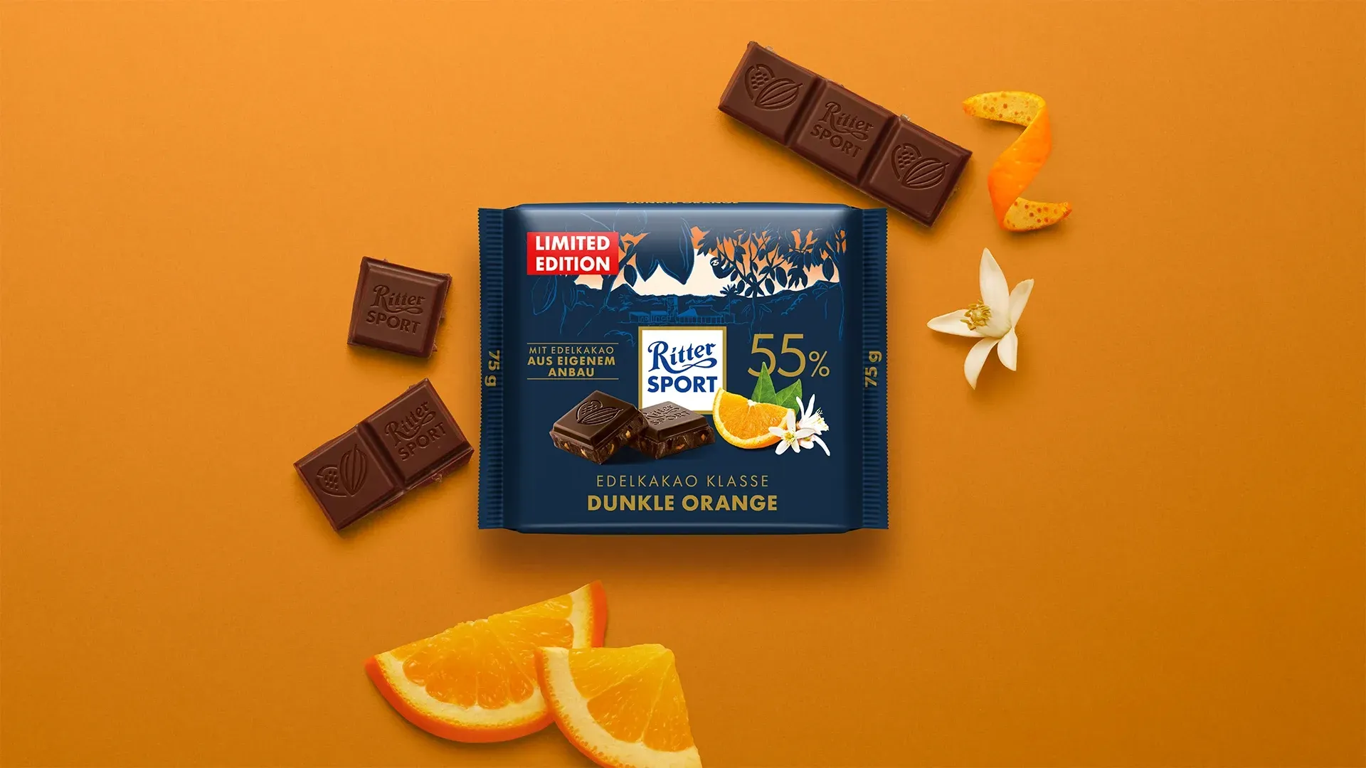Verpackung einer blauen Schokoladentafel mit Nüssen, Schokoladenstückchen und dem Hinweis „55 % Kakaoanteil“ auf blauem Hintergrund