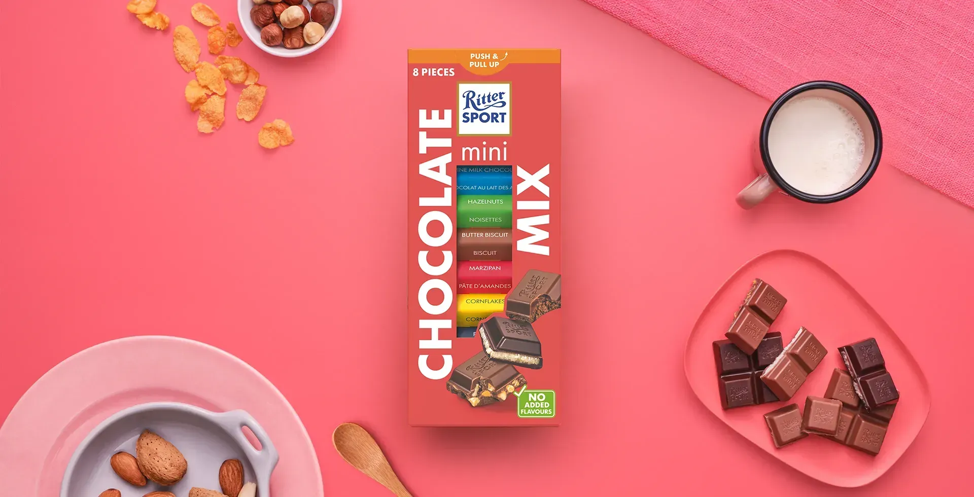 Ritter Sport chocolate bar packaging with cocoa beans, broken chocolate, and milk on a blue background.