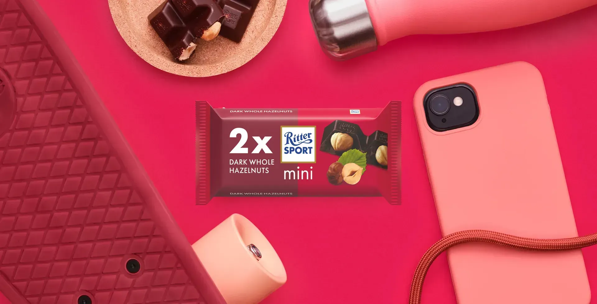Ritter Sport chocolate bar packaging with cocoa beans, broken chocolate, and milk on a blue background.