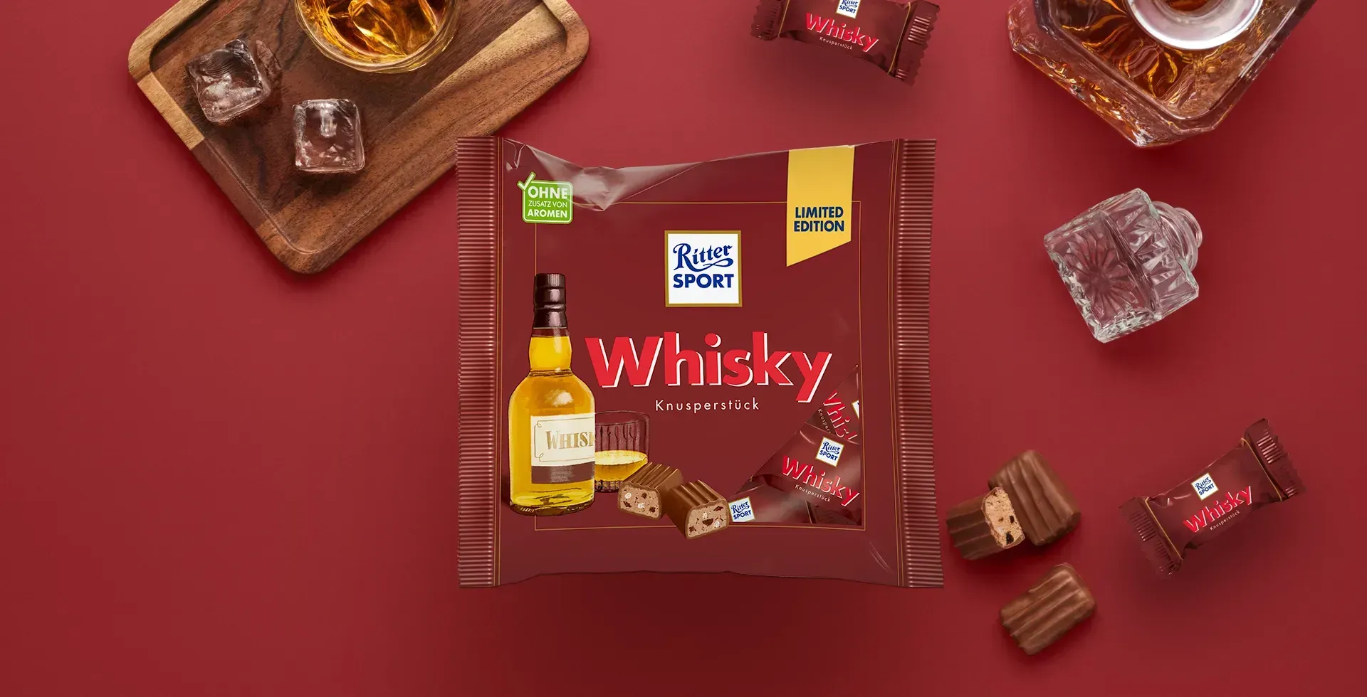Verpackung einer blauen Schokoladentafel mit Nüssen, Schokoladenstückchen und dem Hinweis „55 % Kakaoanteil“ auf blauem Hintergrund